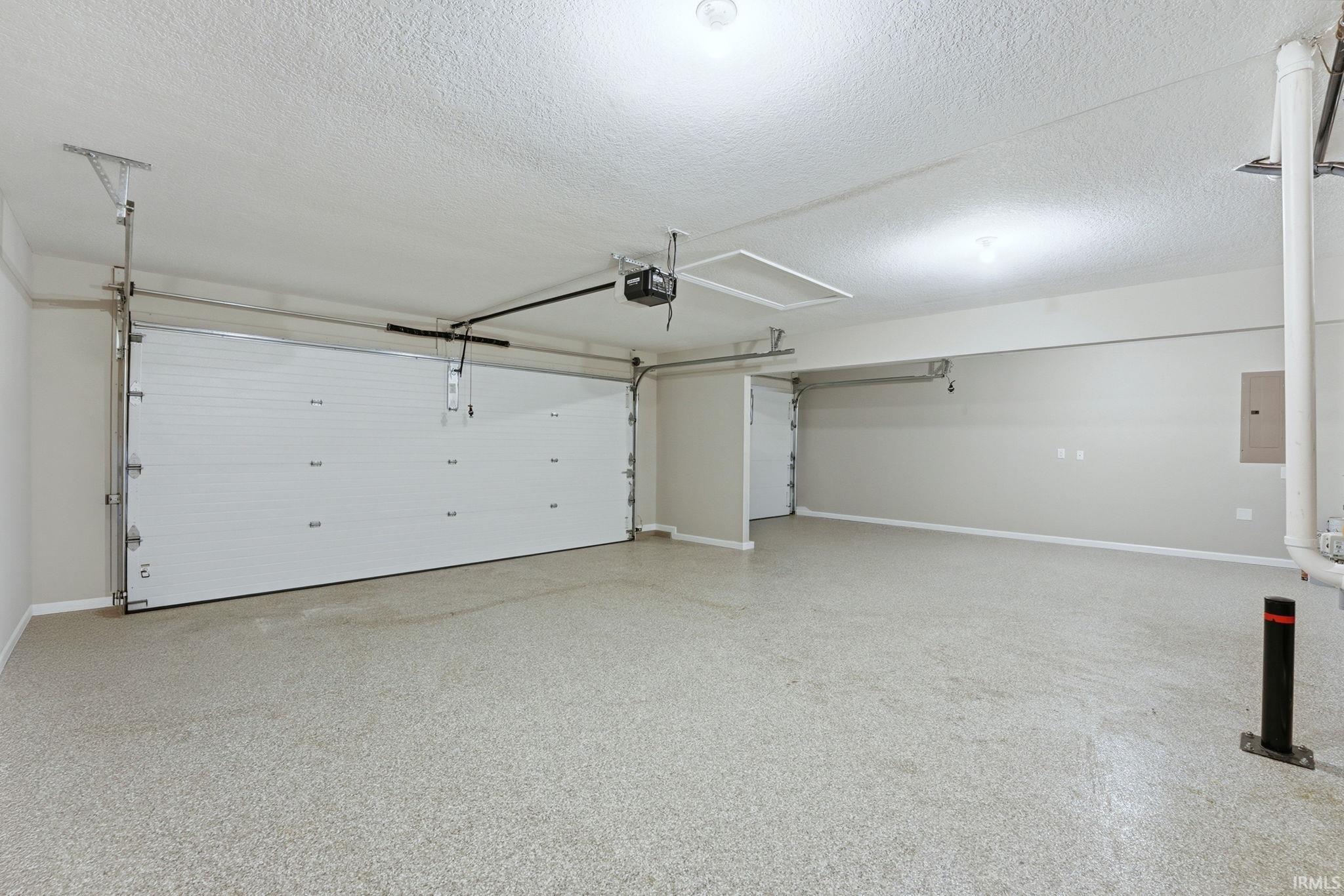 Garage with electric panel and baseboards