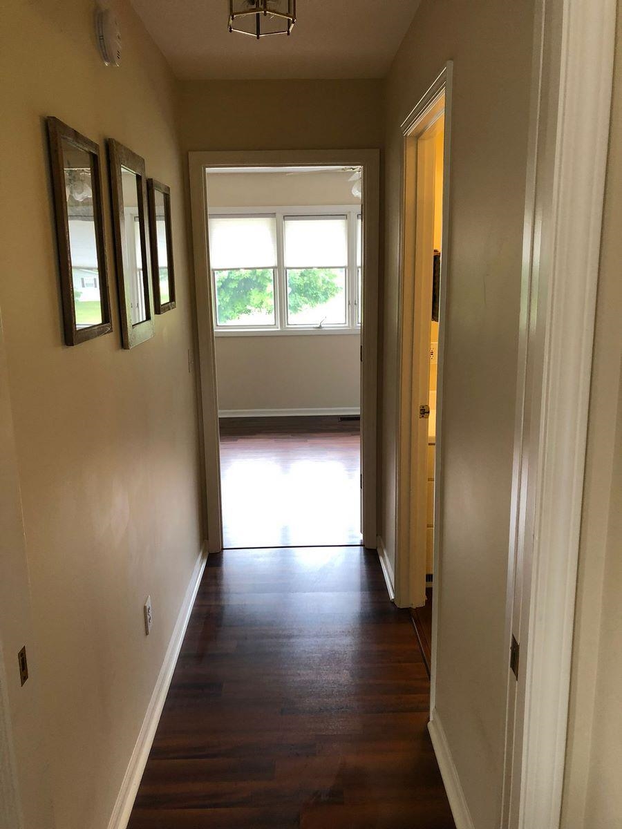 Corridor featuring baseboards and dark wood-type flooring