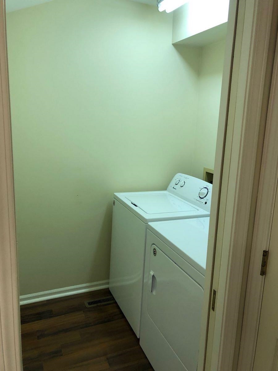 Laundry area featuring dark wood finished floors and separate washer and dryer