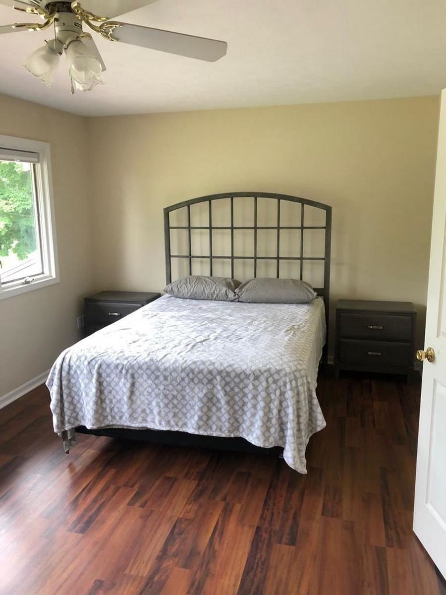 Bedroom featuring dark wood-type flooring and ceiling fan