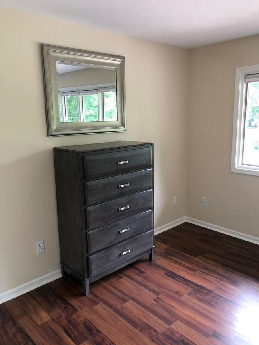 Unfurnished bedroom featuring dark wood-style floors and baseboards