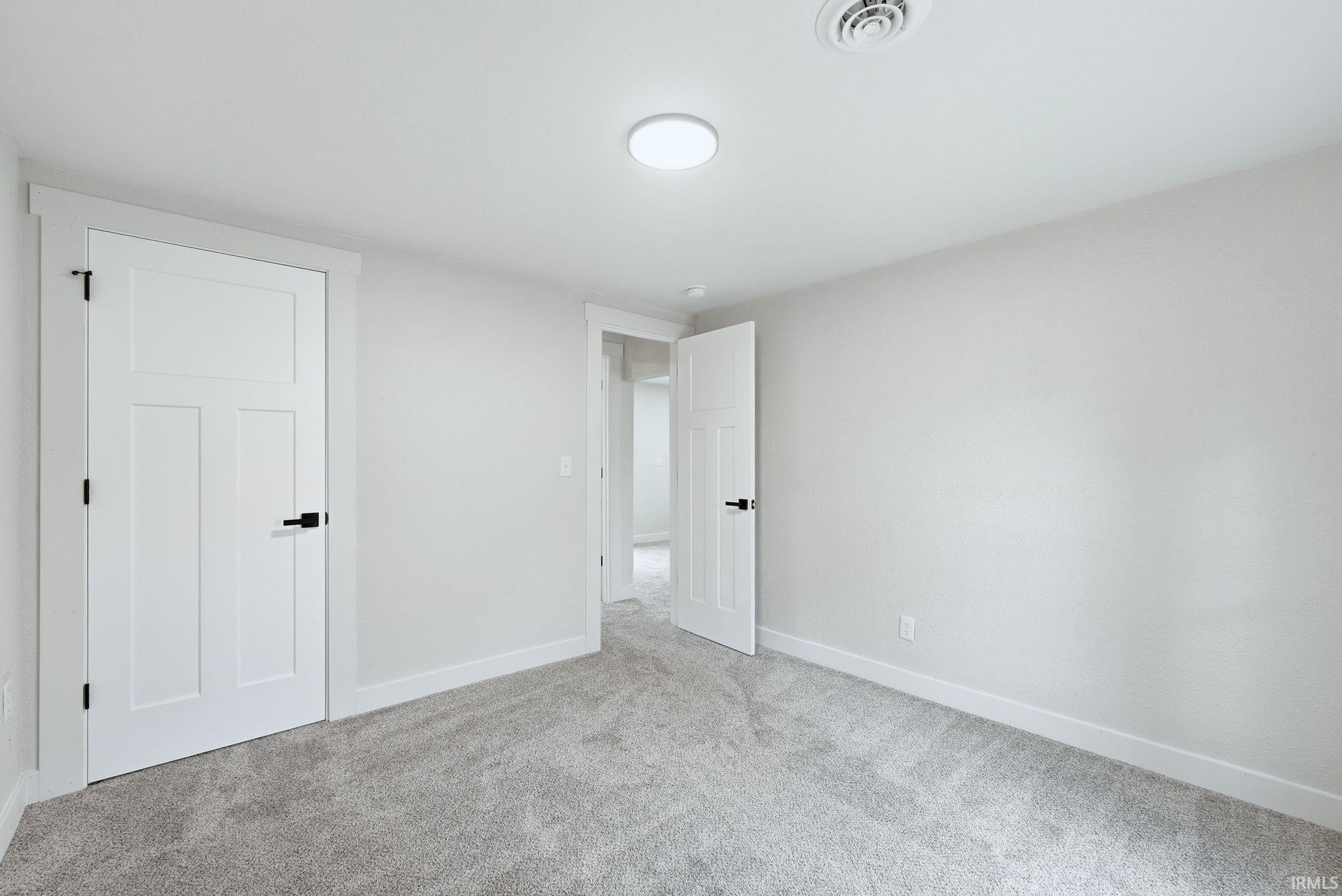 Unfurnished bedroom with baseboards and light colored carpet