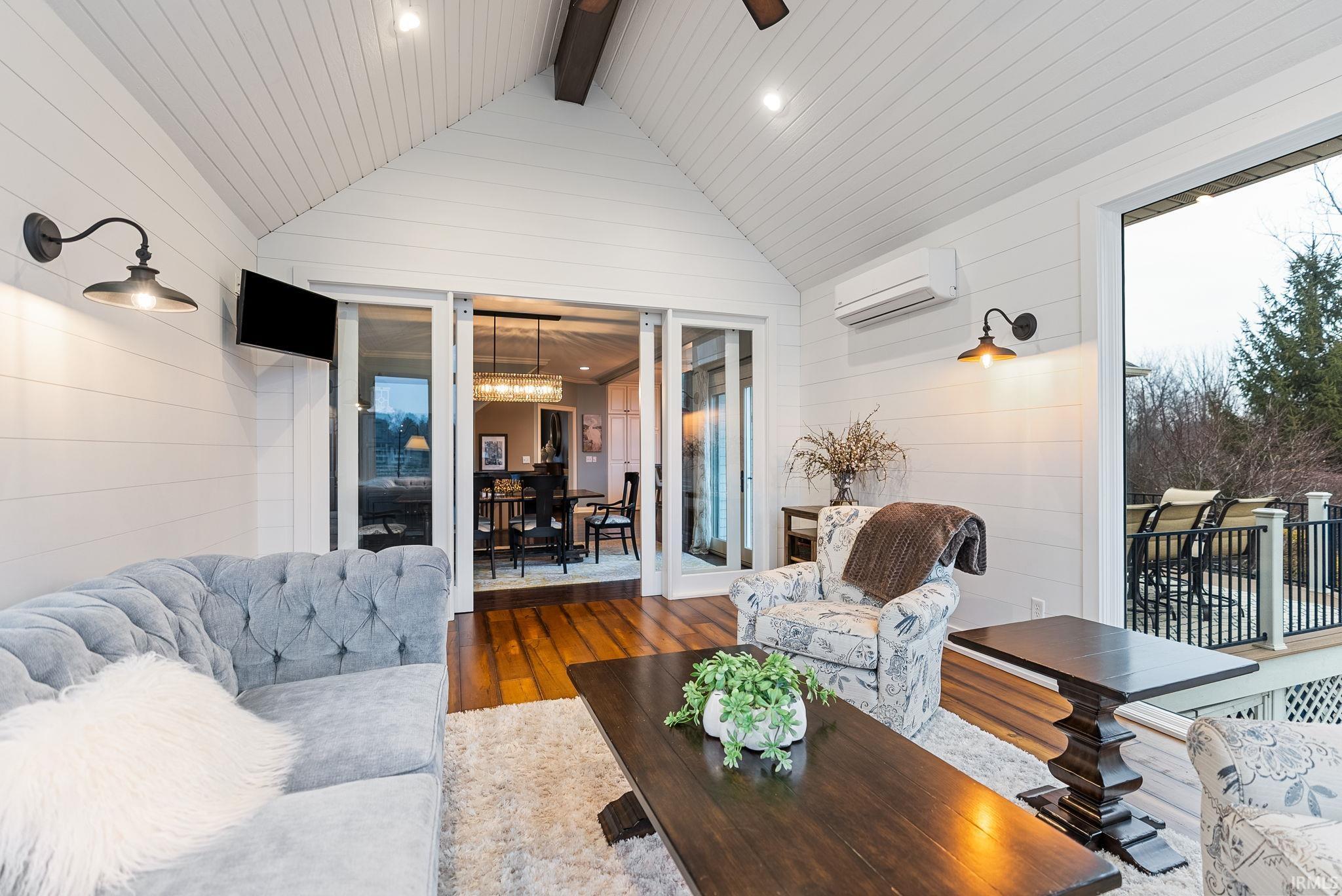 Featuring wood-type flooring, wood walls, recessed lighting, and ceiling fan