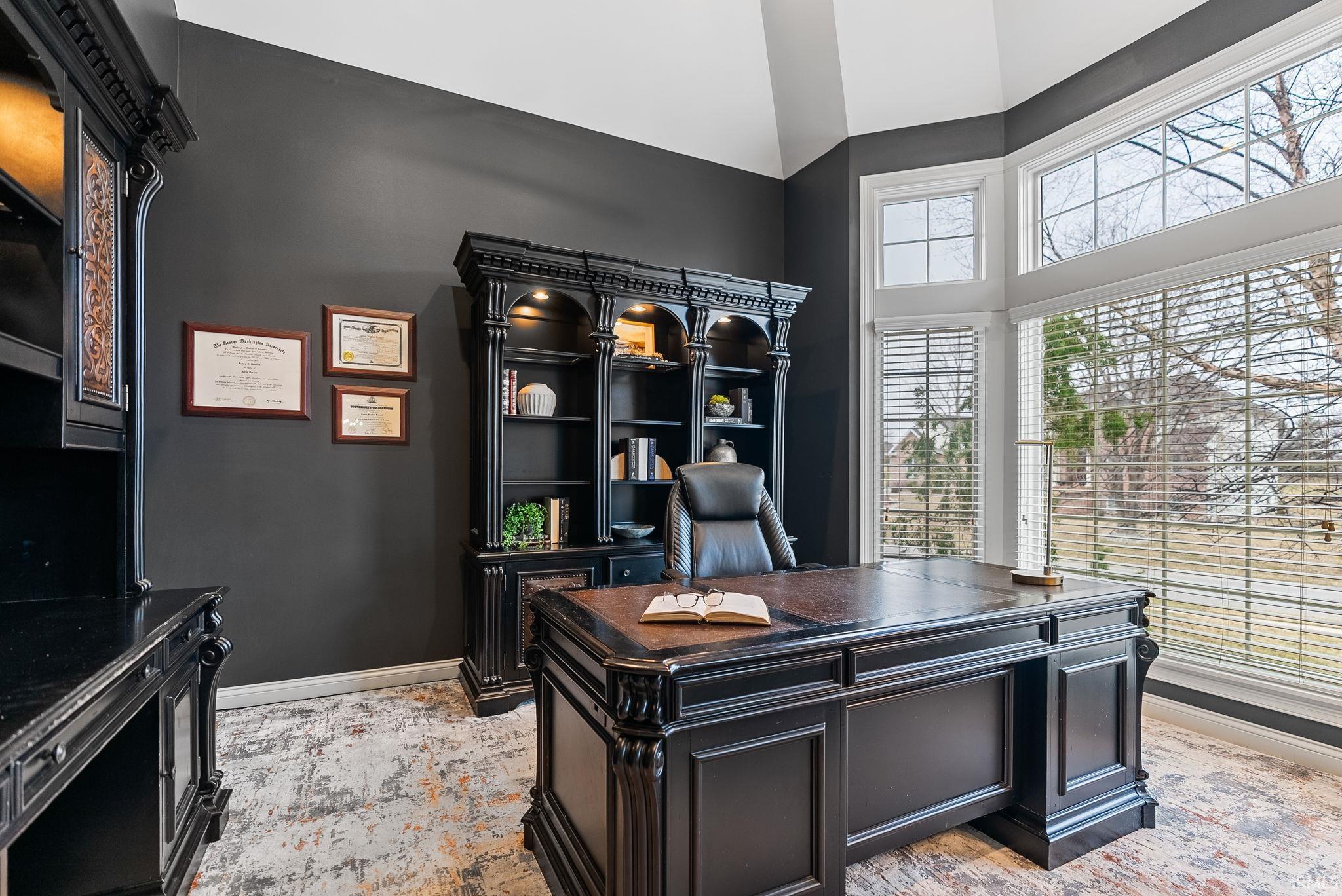 Office space with baseboards and a high ceiling