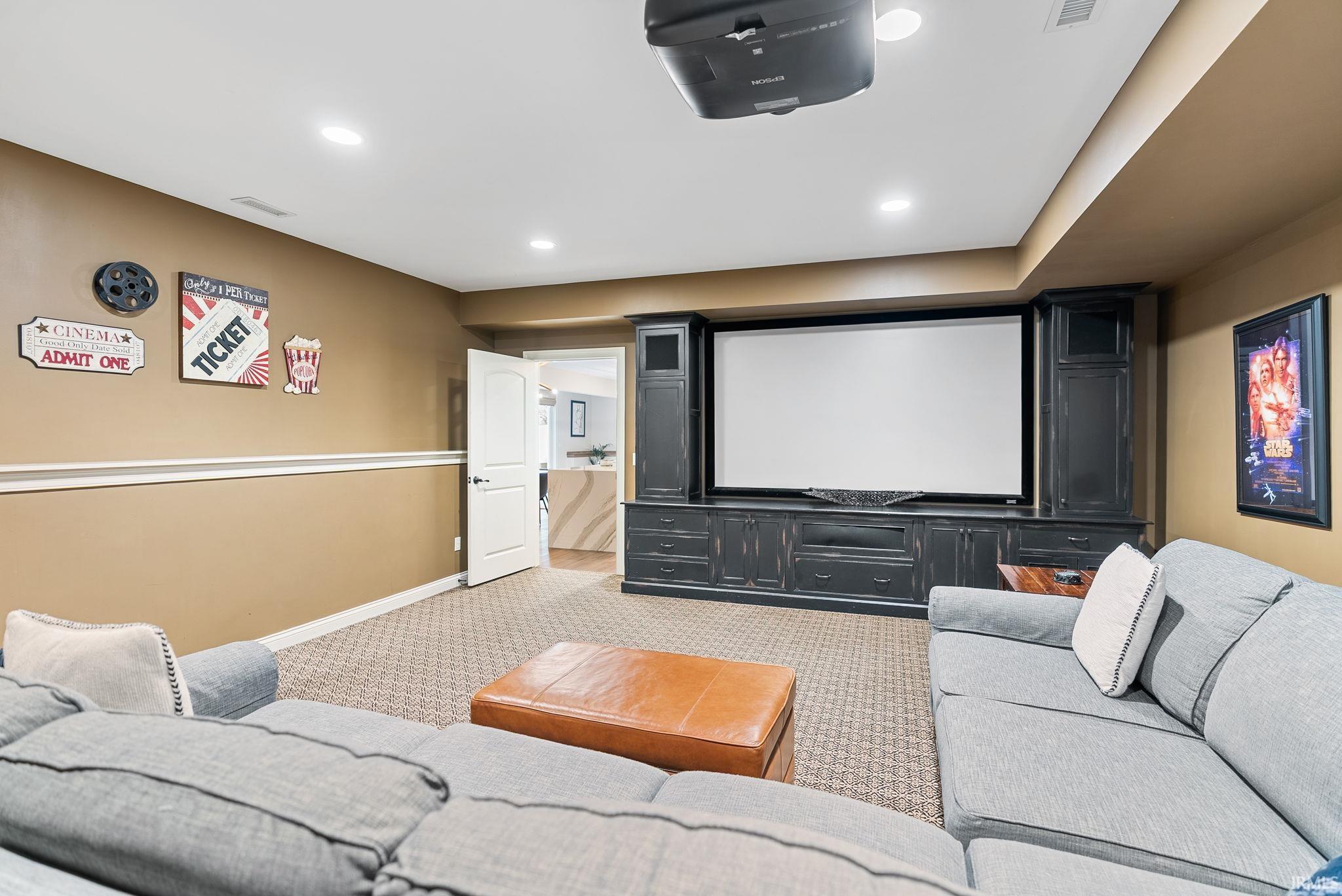 Home theater room with light colored carpet and recessed lighting