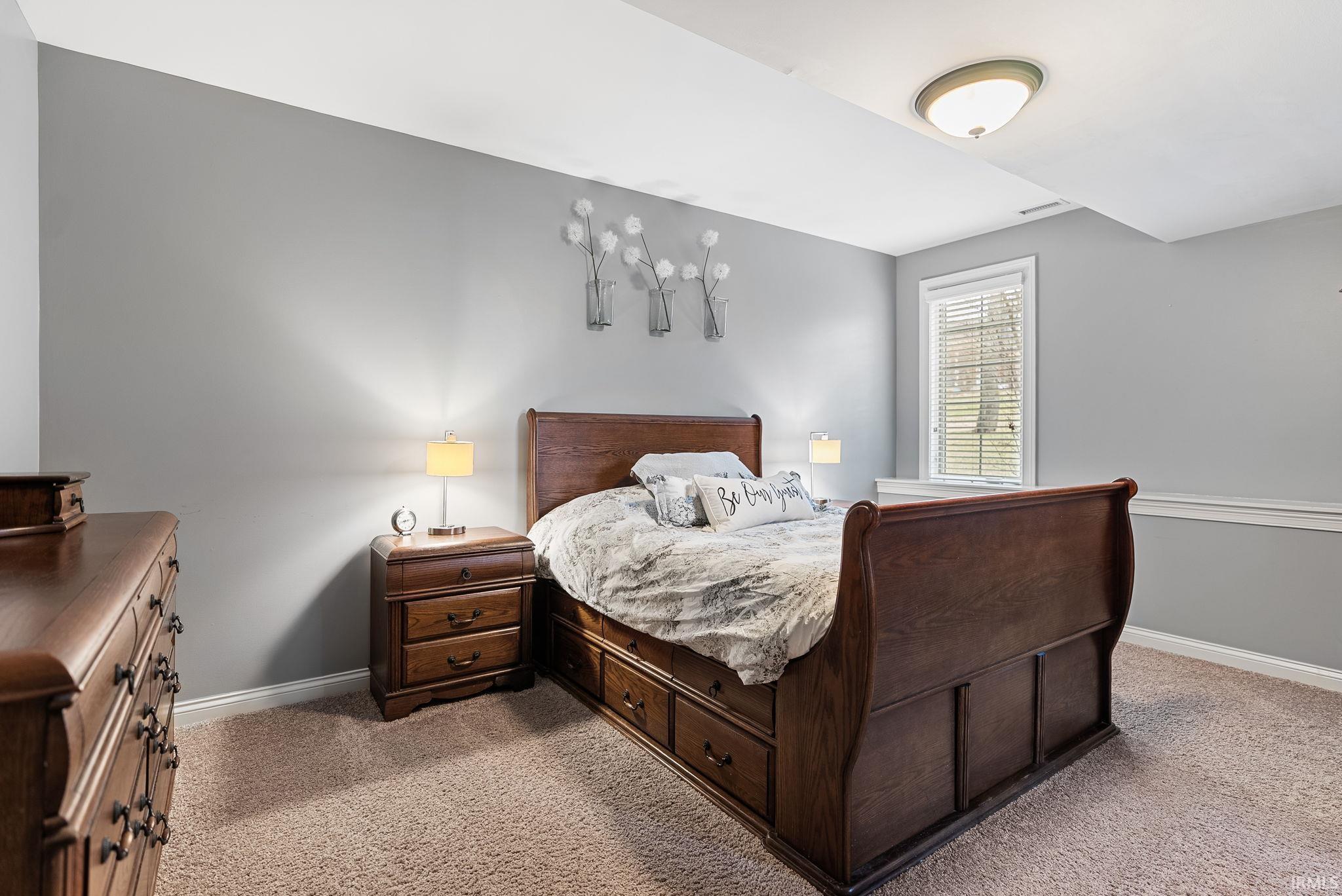 Bedroom featuring light carpet