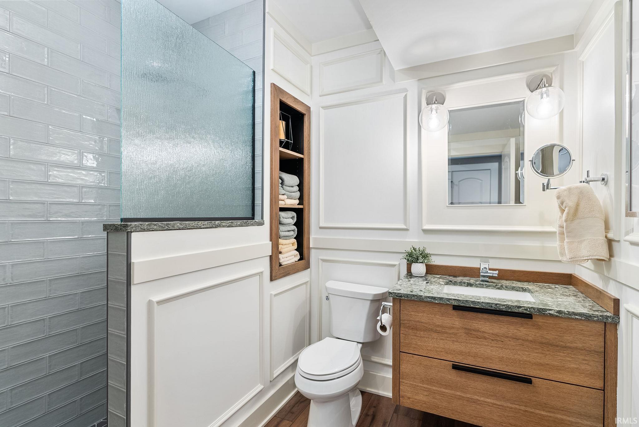 Full bathroom with vanity, dark wood-type flooring, and walk in shower