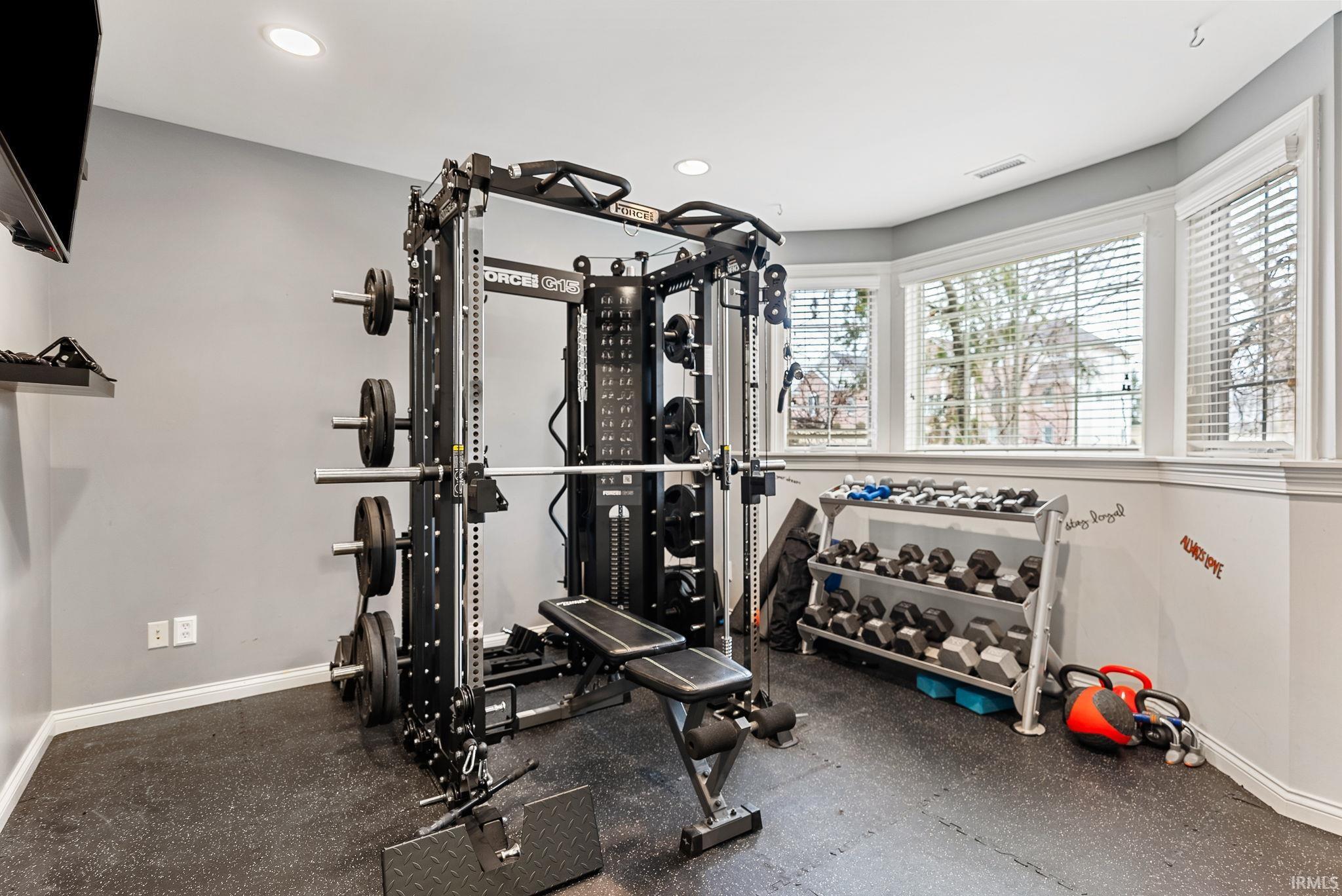 Workout area with dark rubber floors and recessed lighting