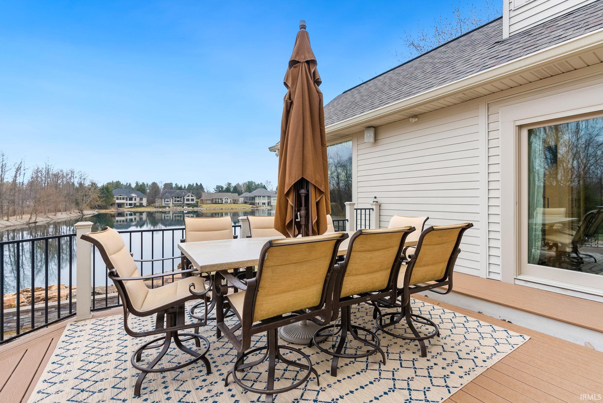Deck featuring outdoor dining area, a water view, and a residential view