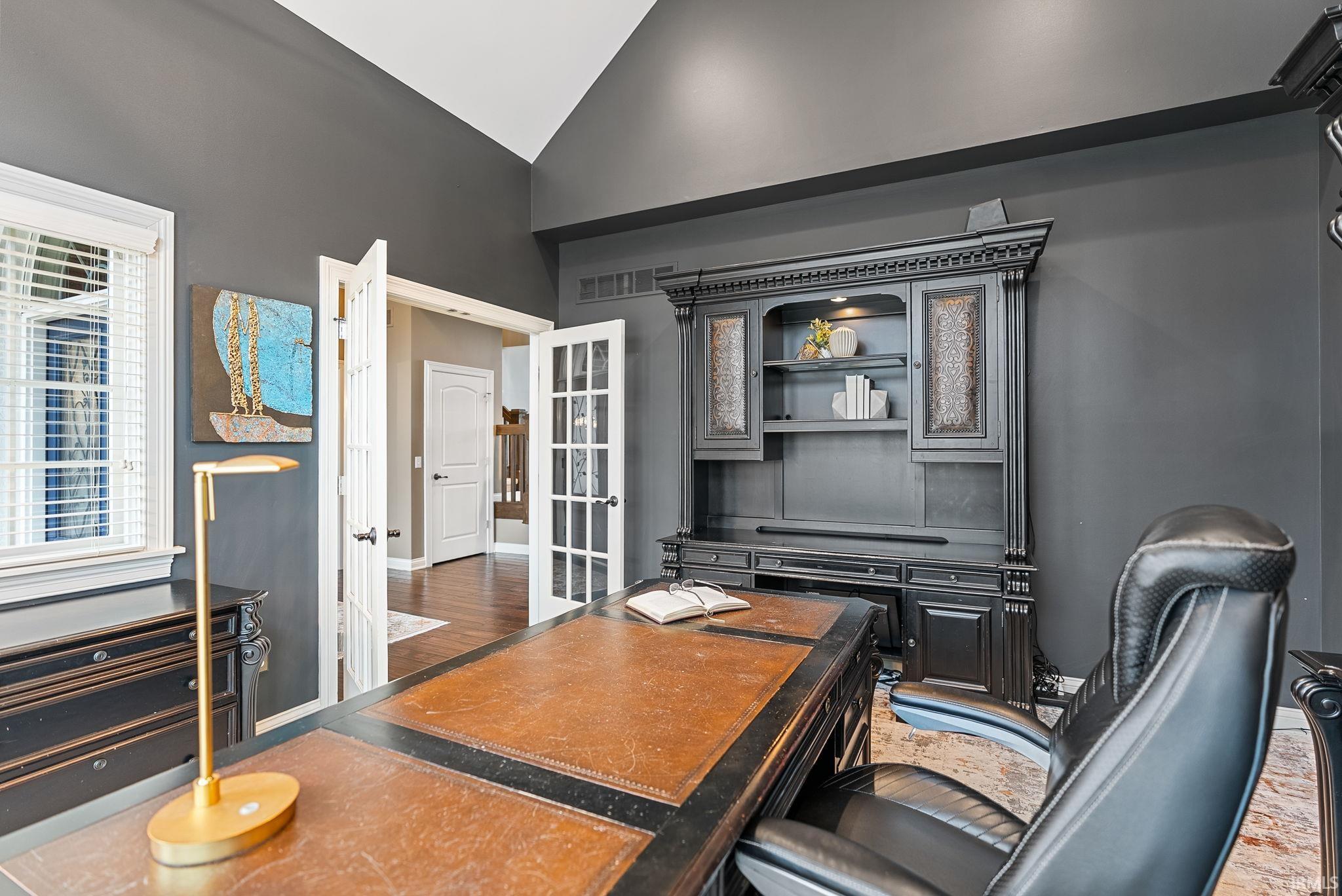 Office with lofted ceiling and baseboards