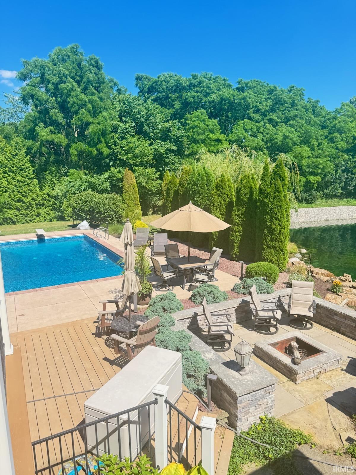 Outdoor pool with a patio area and an outdoor fire pit