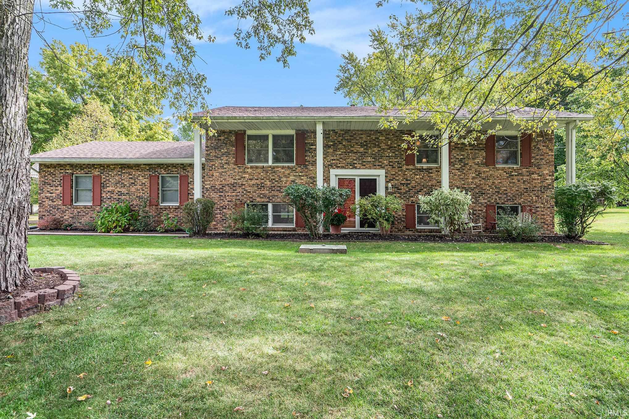 Bi-level home with a front yard and brick siding
