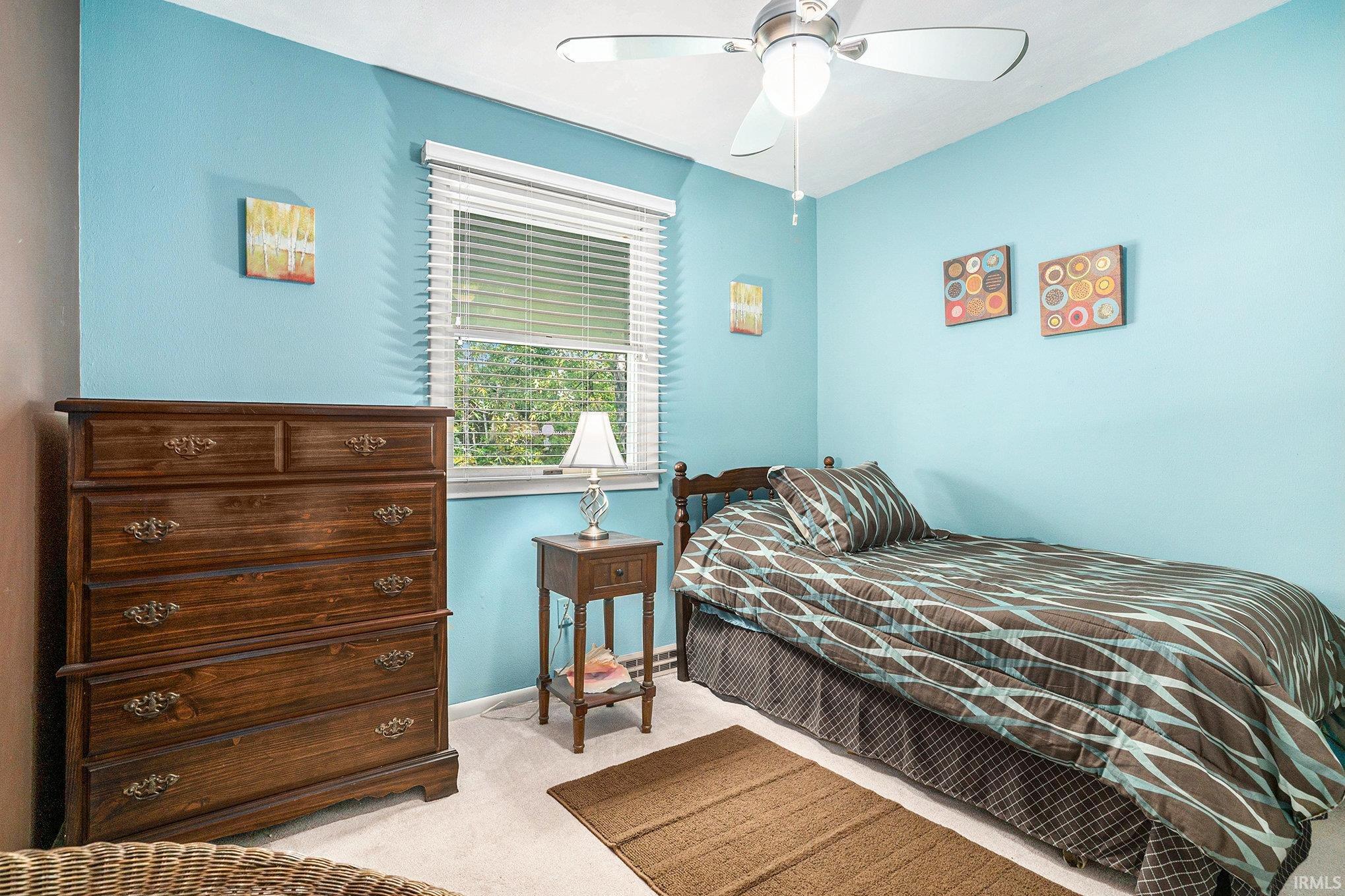 Bedroom featuring light colored carpet and a ceiling fan