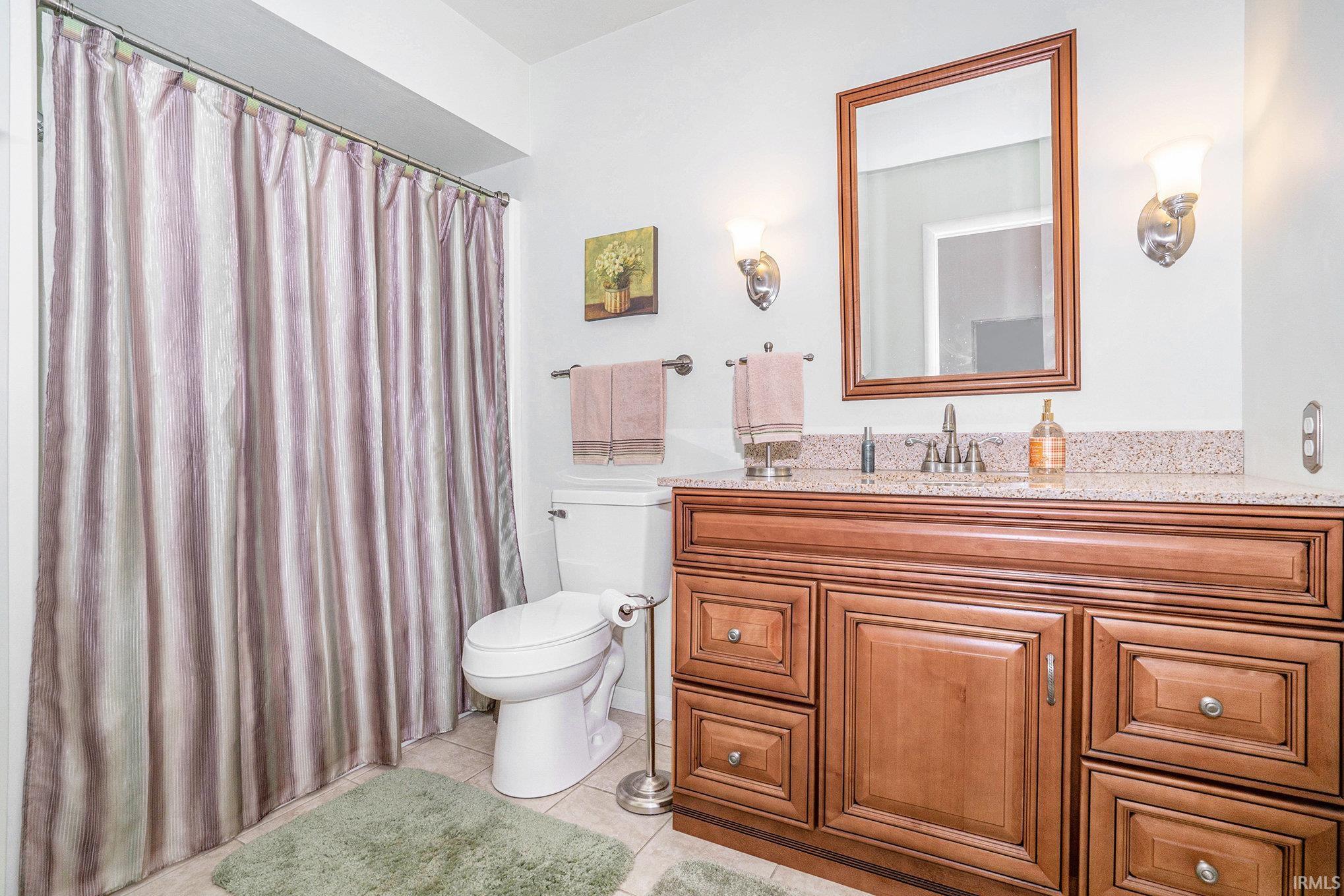Bathroom featuring vanity, a shower with shower curtain, and light tile patterned floors