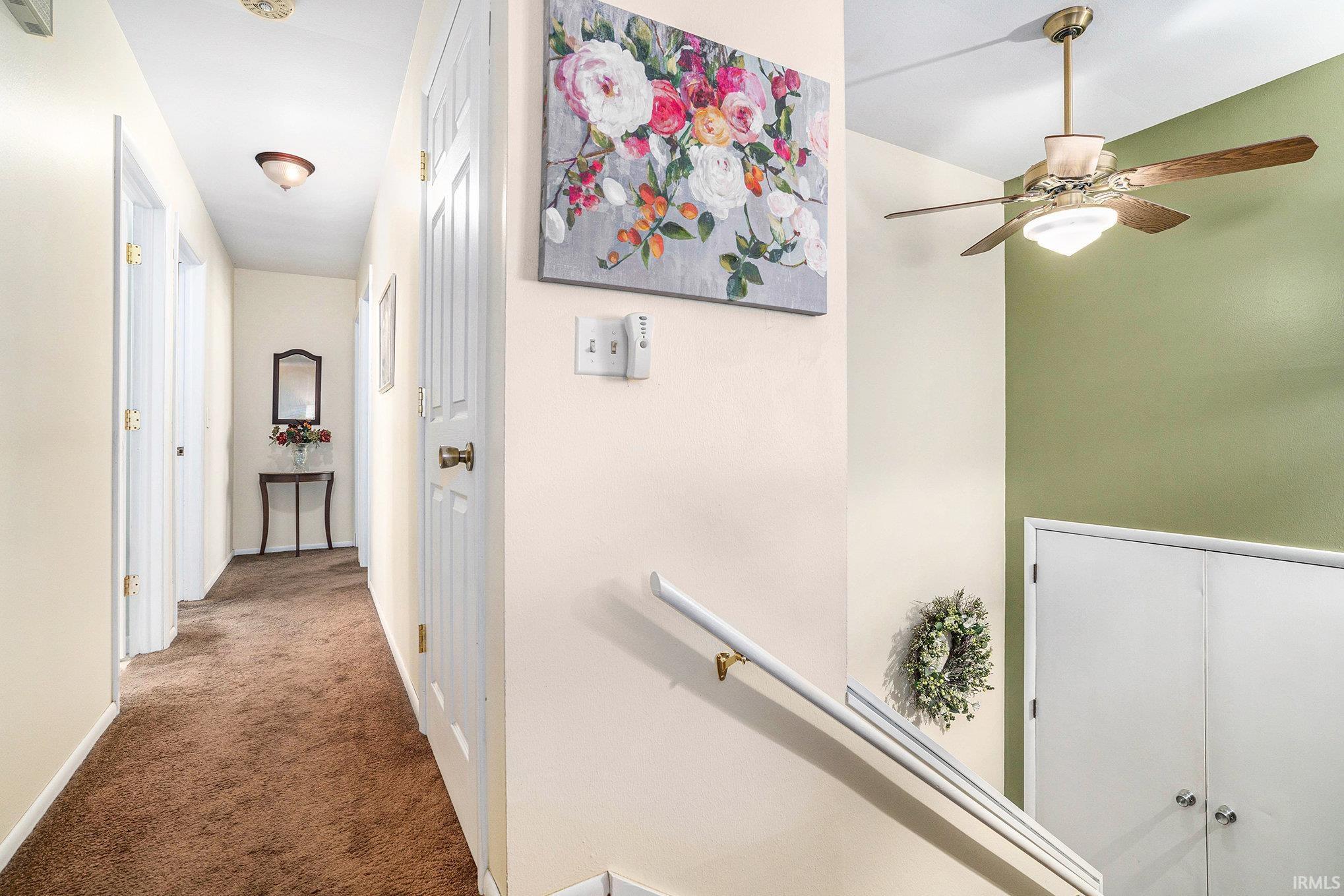 Corridor featuring carpet and an upstairs landing