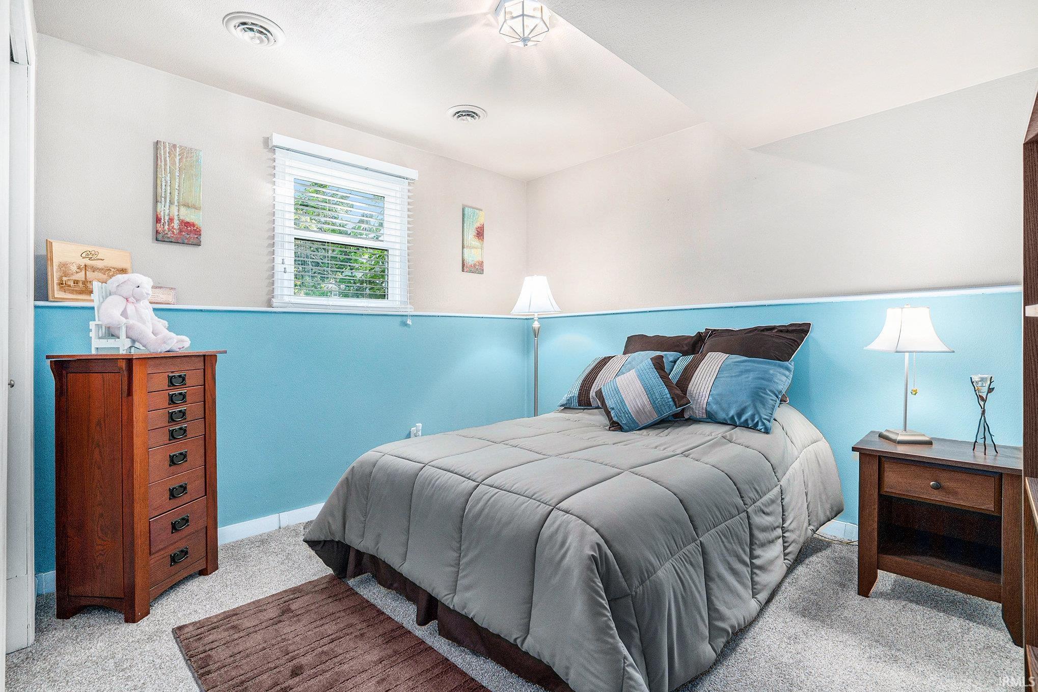 Bedroom with light carpet and baseboards