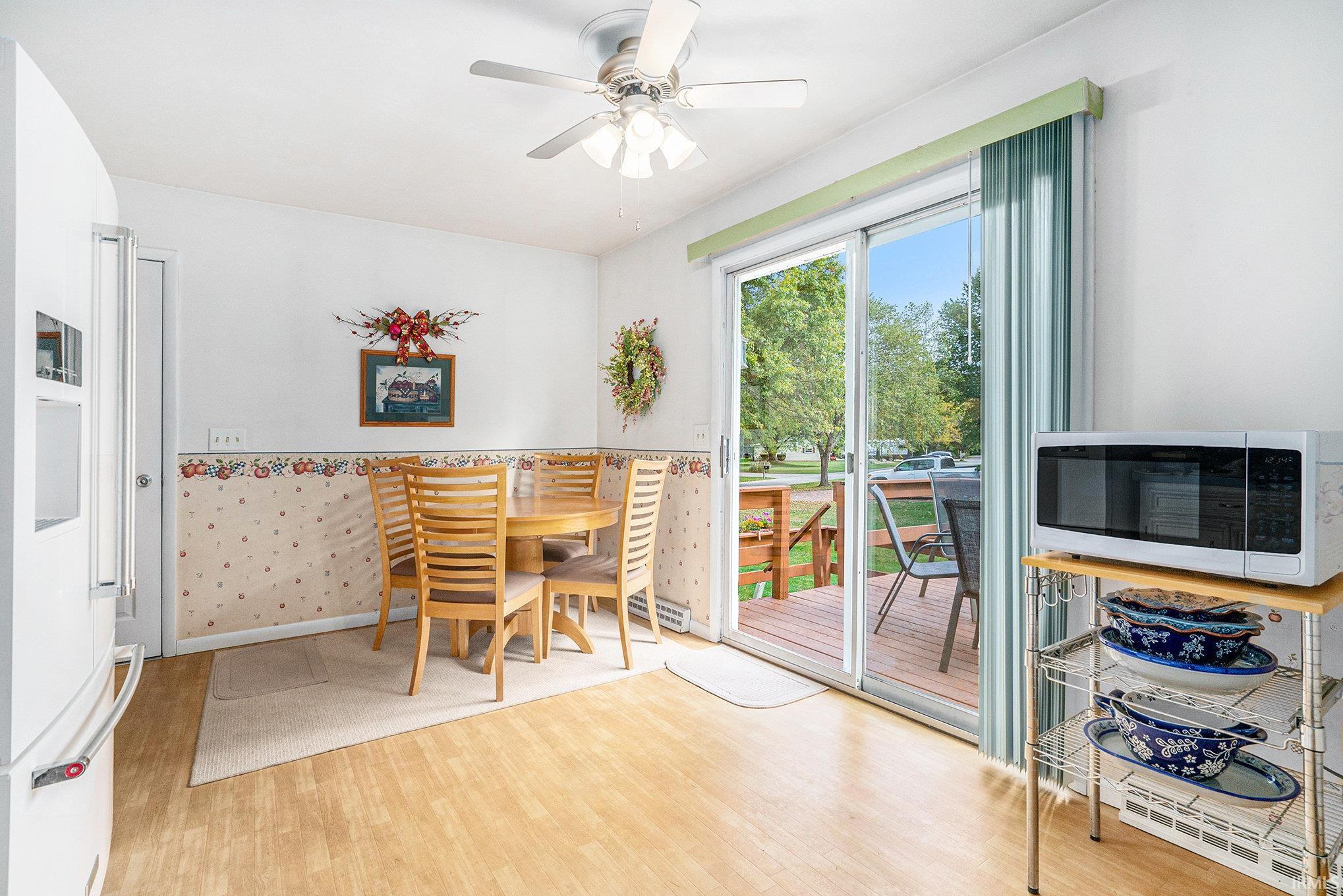 Dining space with light wood-style floors and a ceiling fan