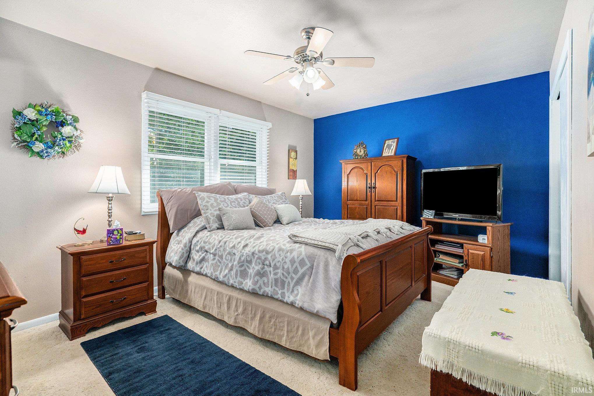 Bedroom with a ceiling fan and light carpet
