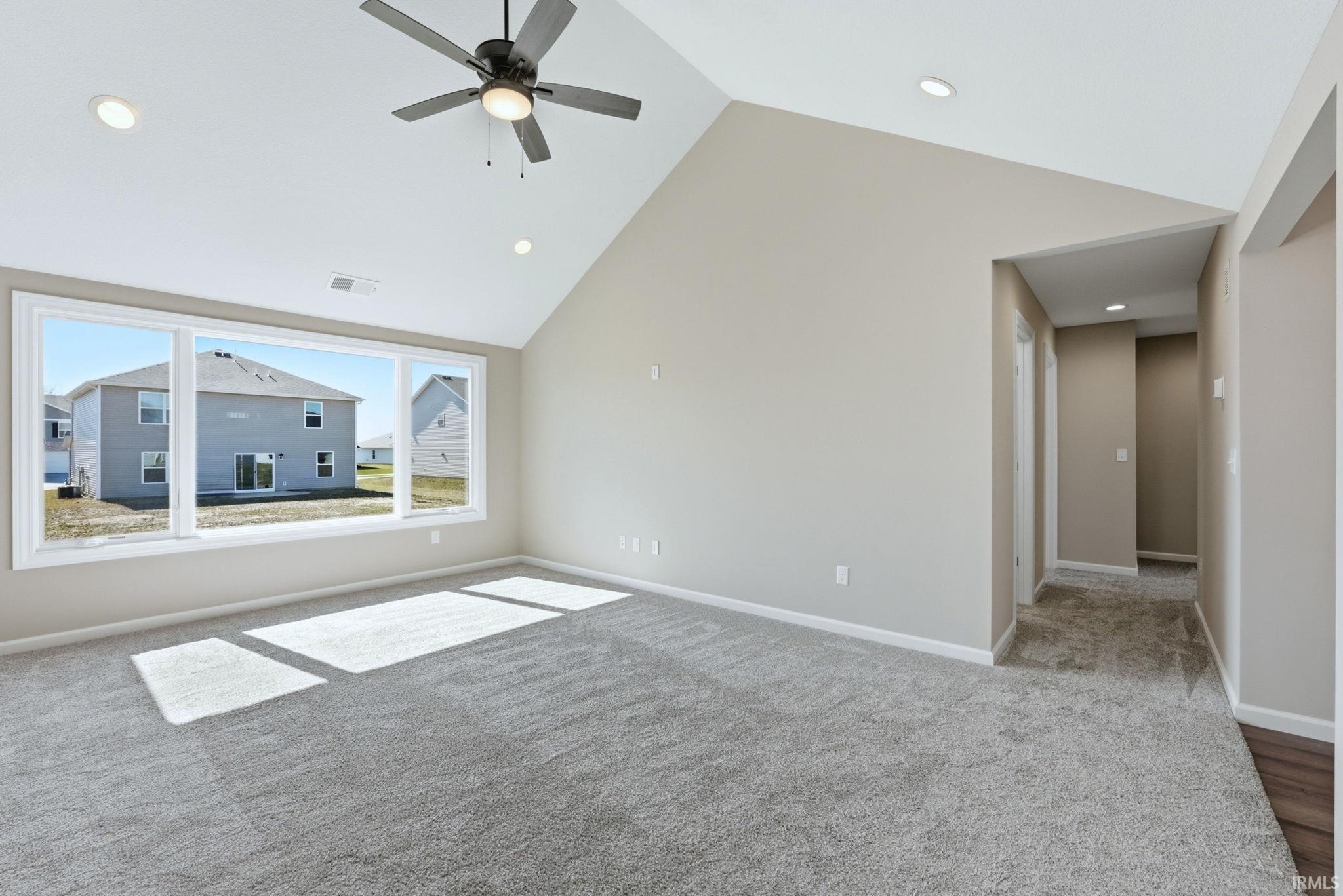 Unfurnished room with a ceiling fan, a high ceiling, light carpet, and recessed lighting