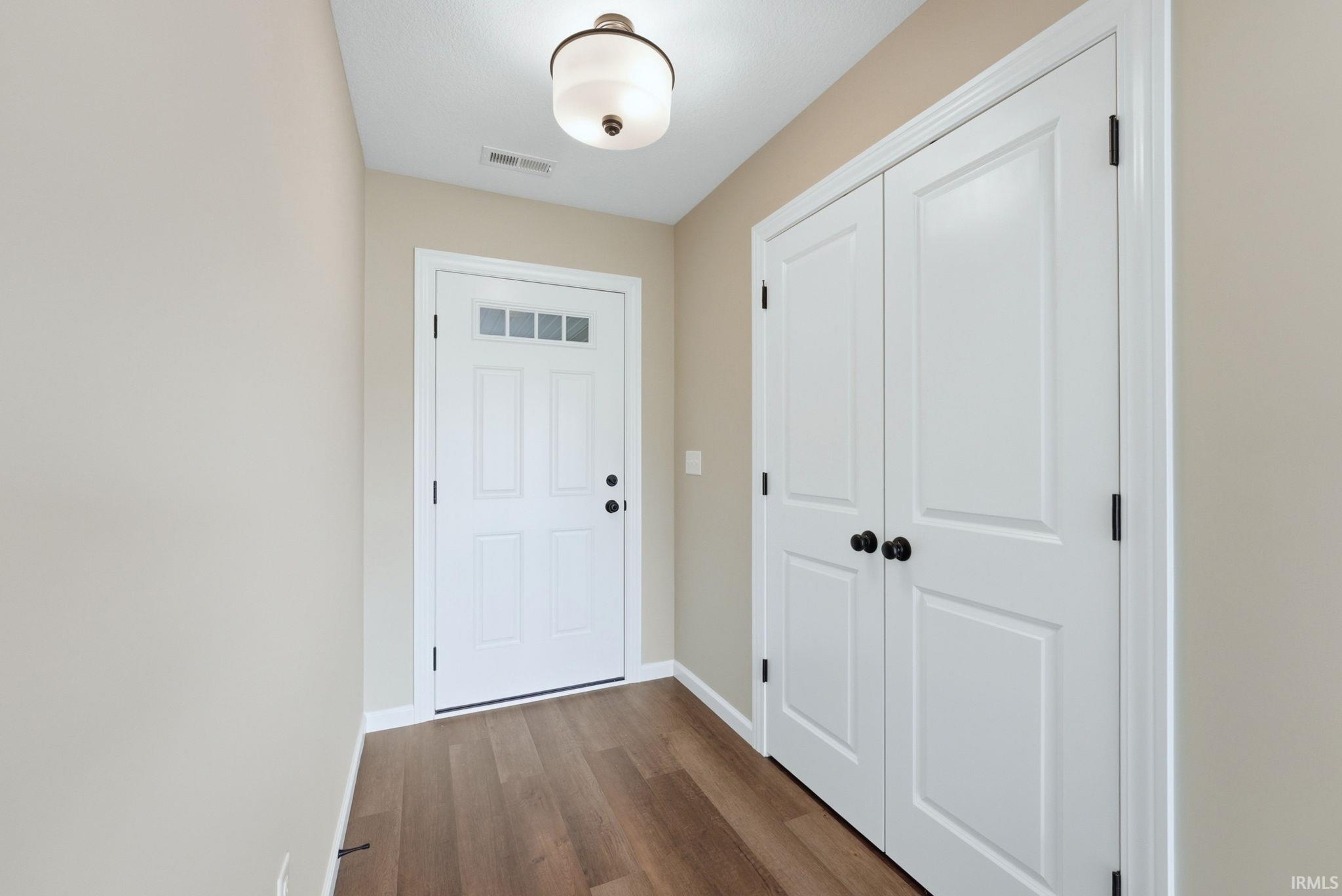 Doorway featuring wood finished floors and baseboards
