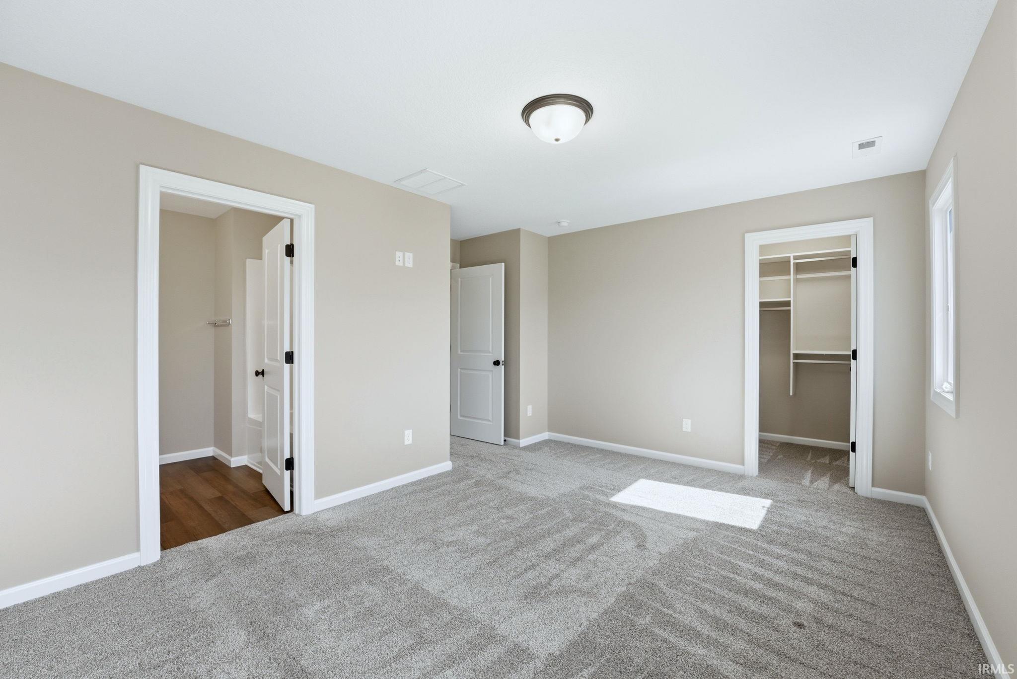 Unfurnished bedroom featuring a spacious closet and light carpet