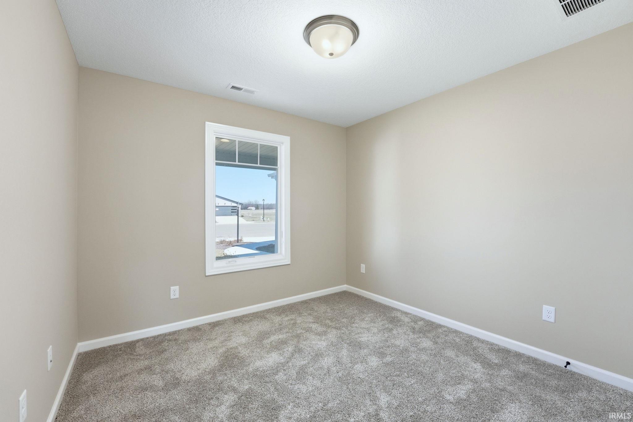 Carpeted empty room with baseboards
