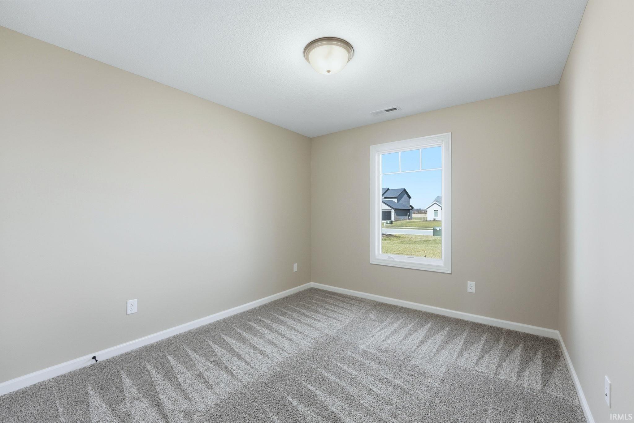 Empty room with baseboards and light colored carpet