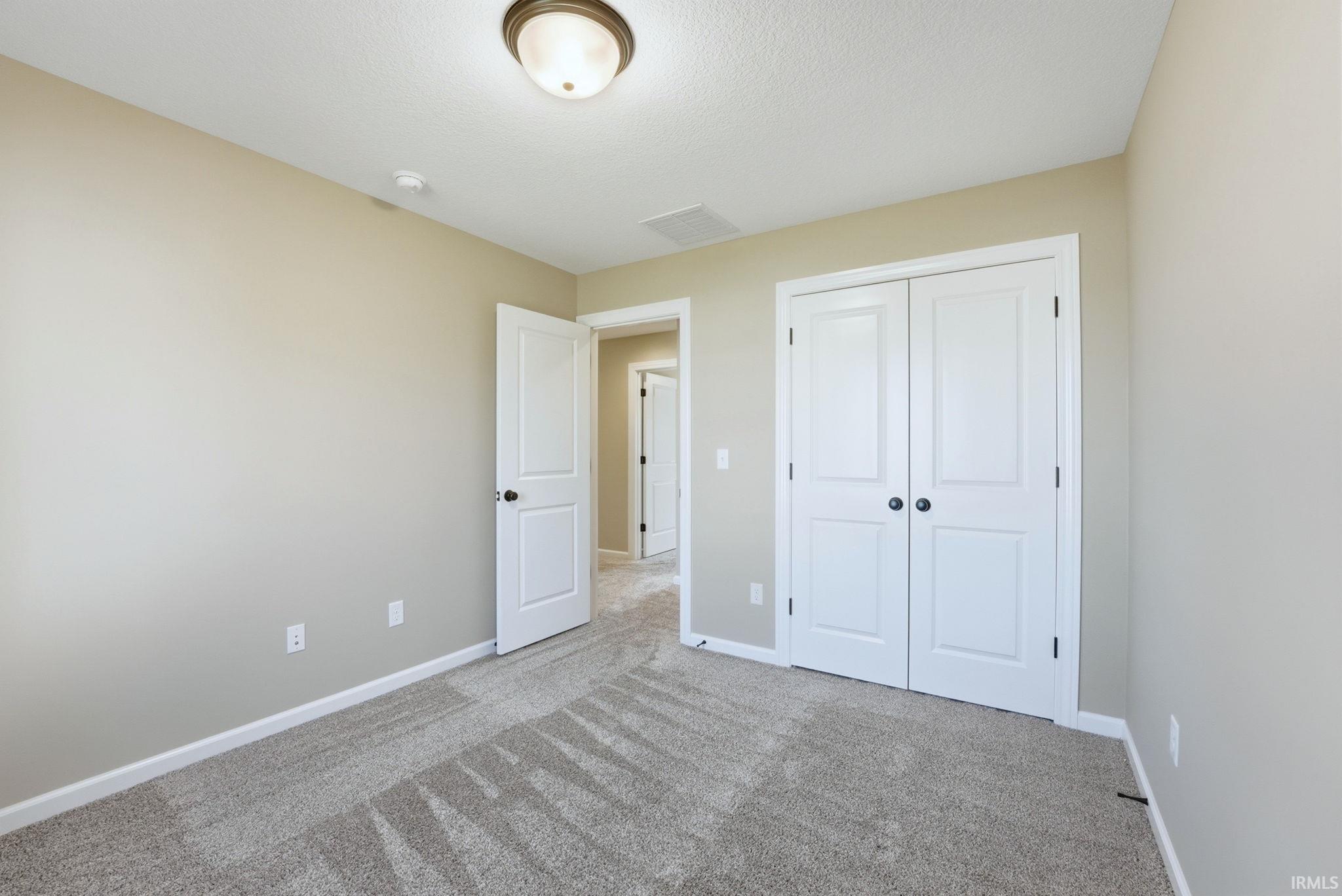 Unfurnished bedroom featuring carpet flooring and a closet