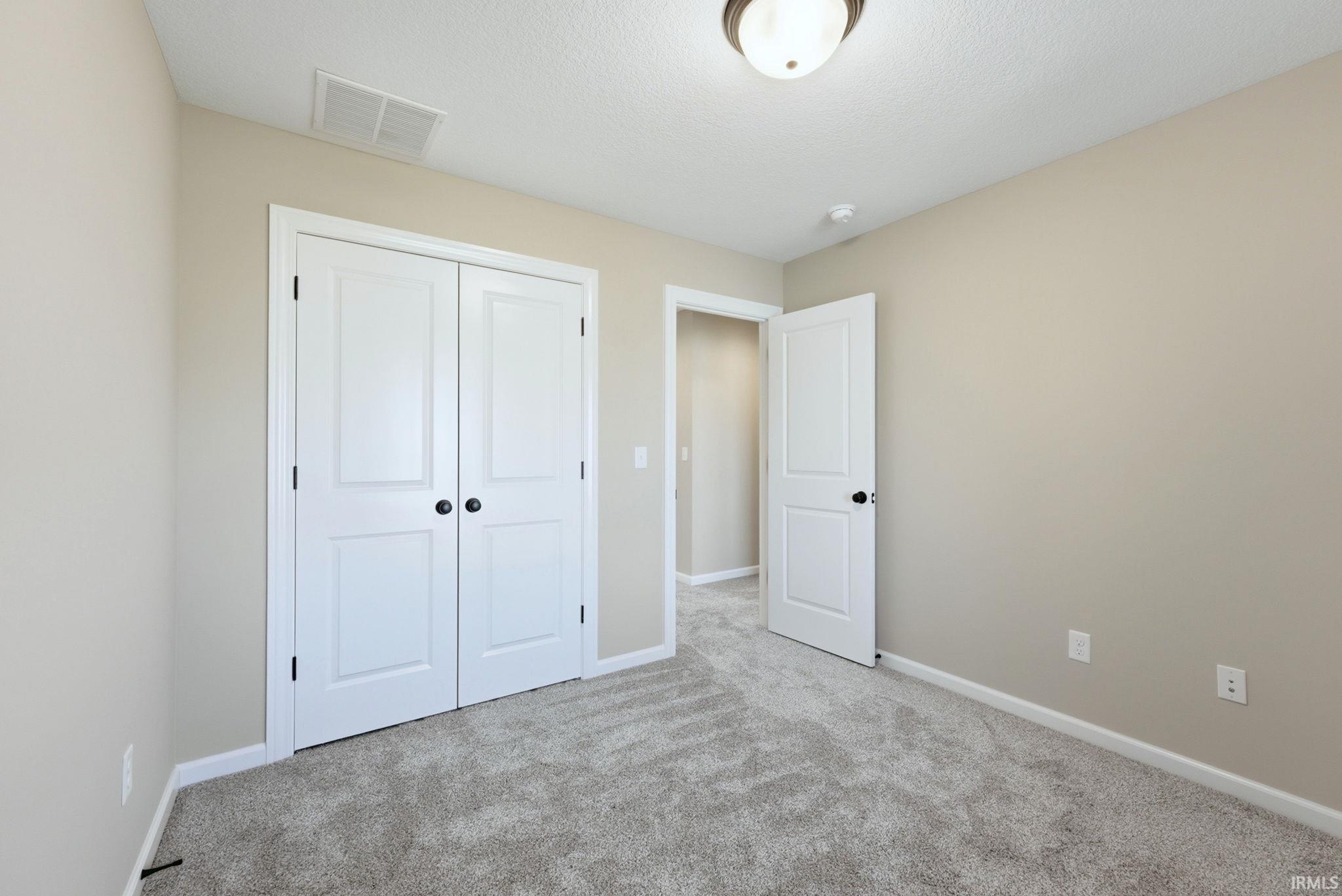 Unfurnished bedroom featuring carpet floors, a closet, and a textured ceiling