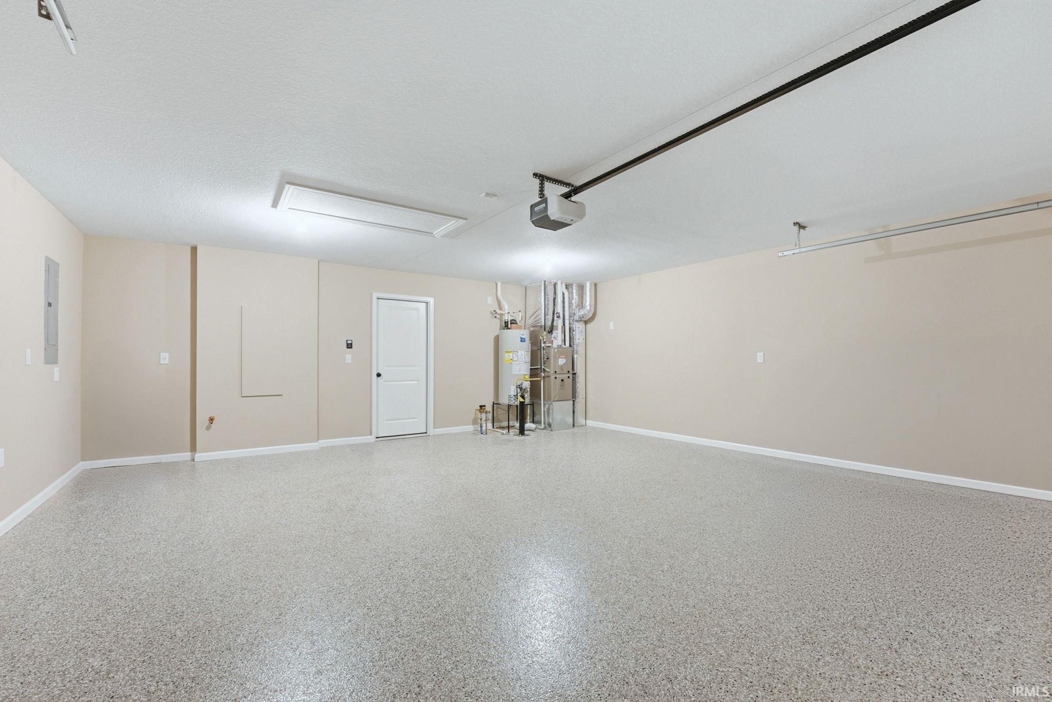 Garage featuring water heater and electric panel
