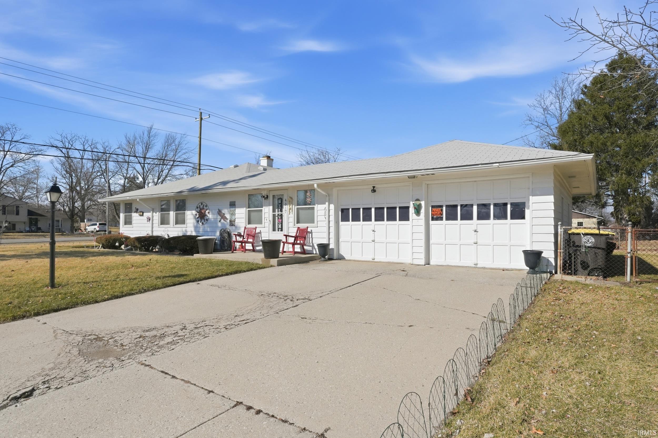 Single story home featuring concrete driveway and a garage