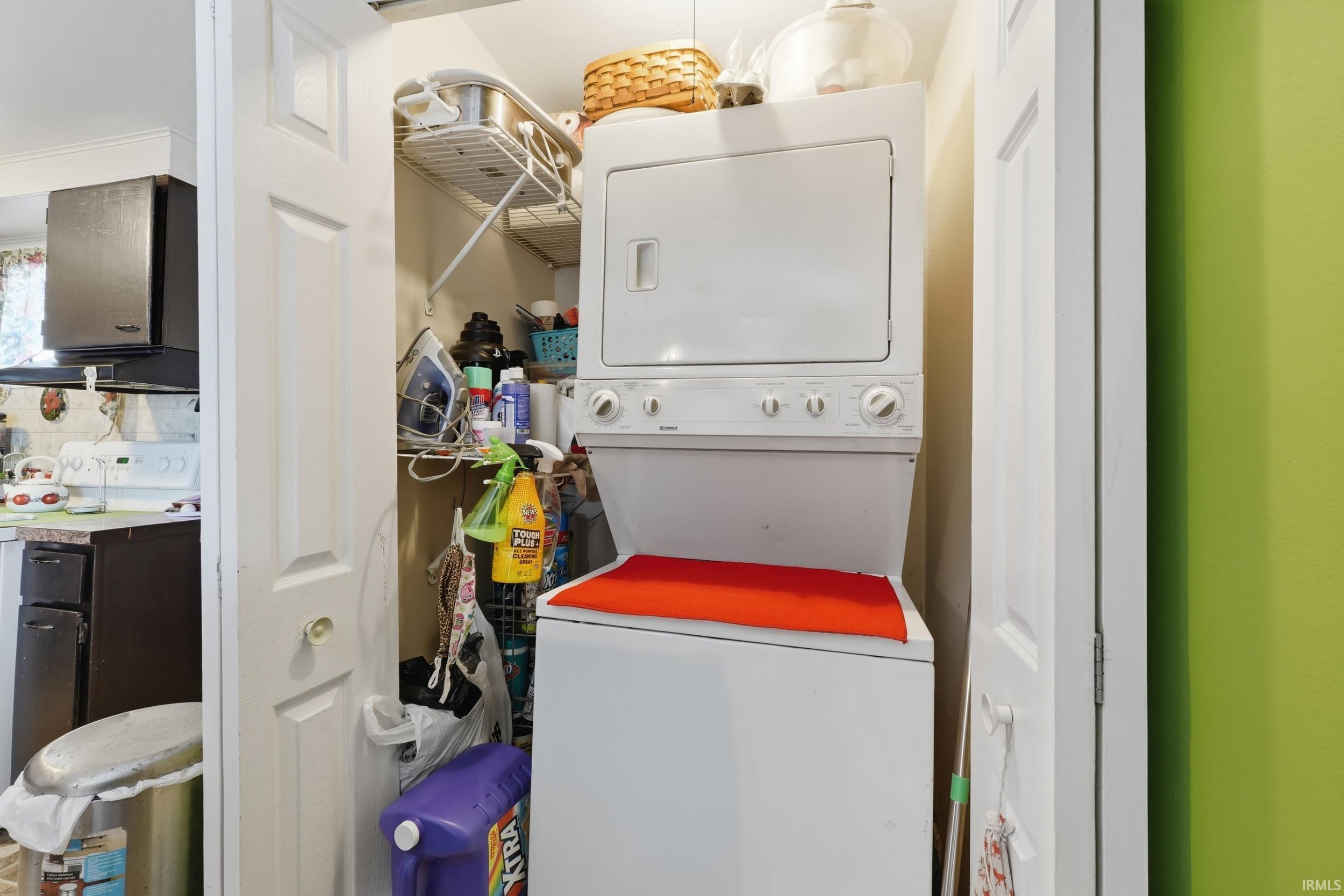 Laundry area with stacked washer and clothes dryer