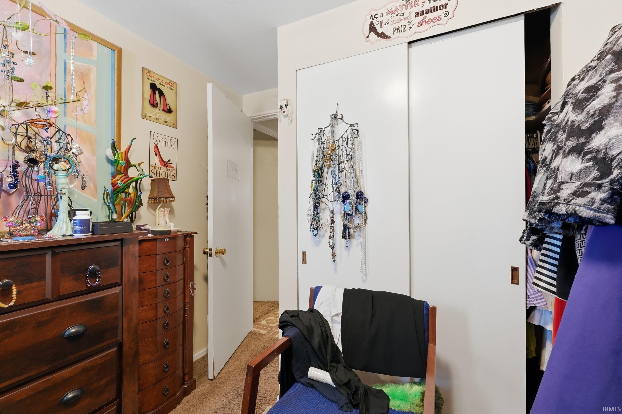 Bedroom featuring light carpet and a closet
