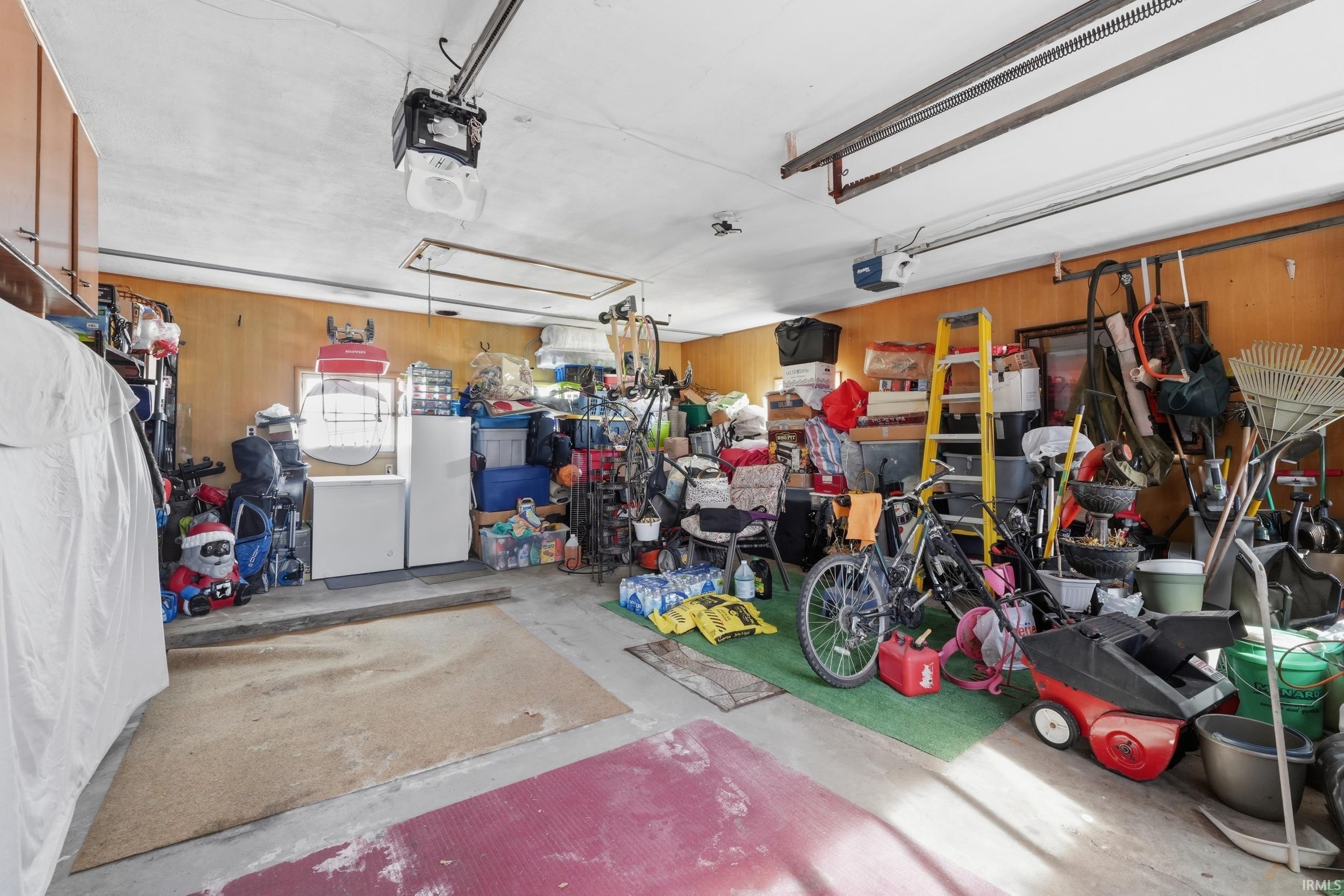 Garage with wooden walls and a garage door opener