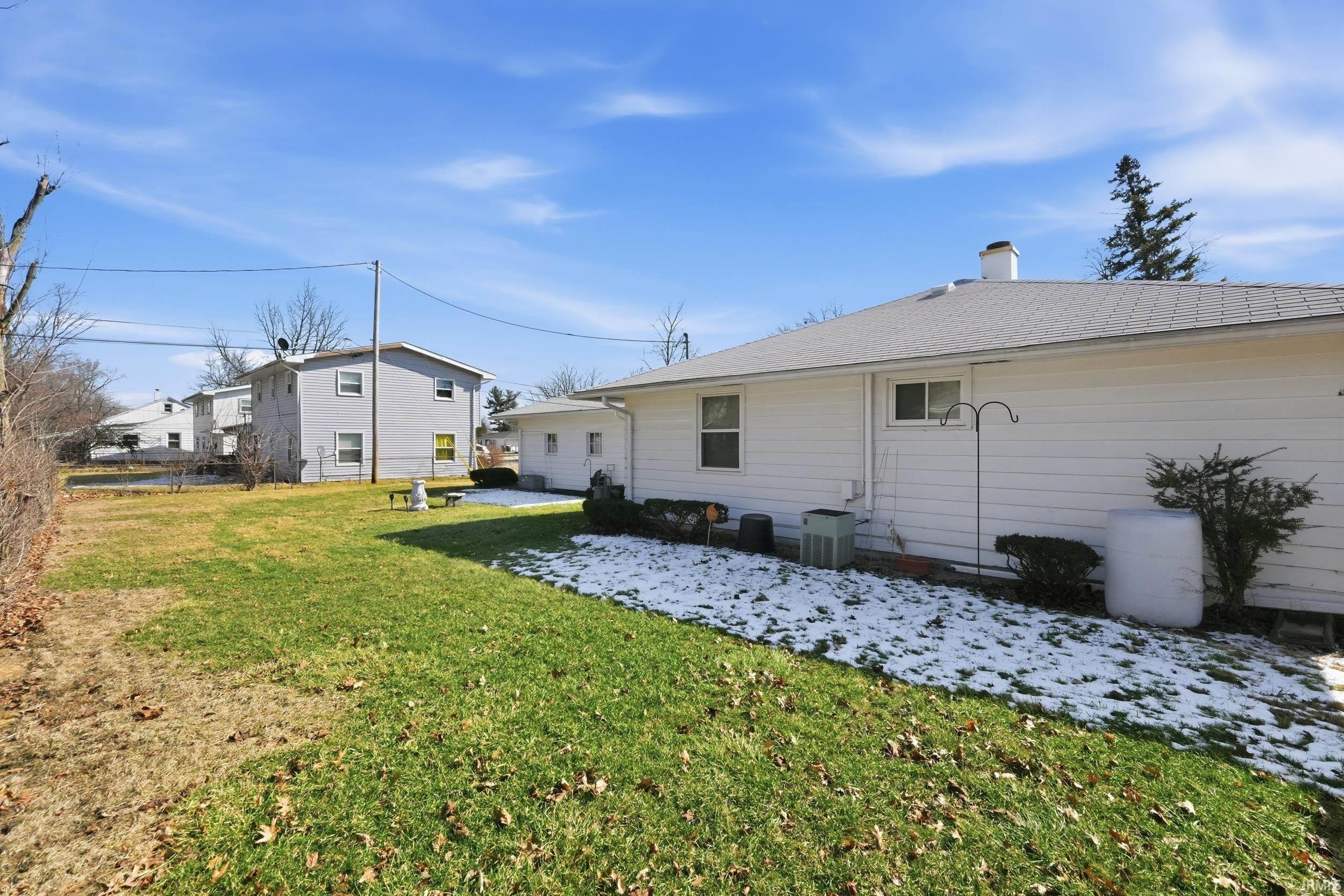 Rear view of house with a yard, a patio, and a chimney