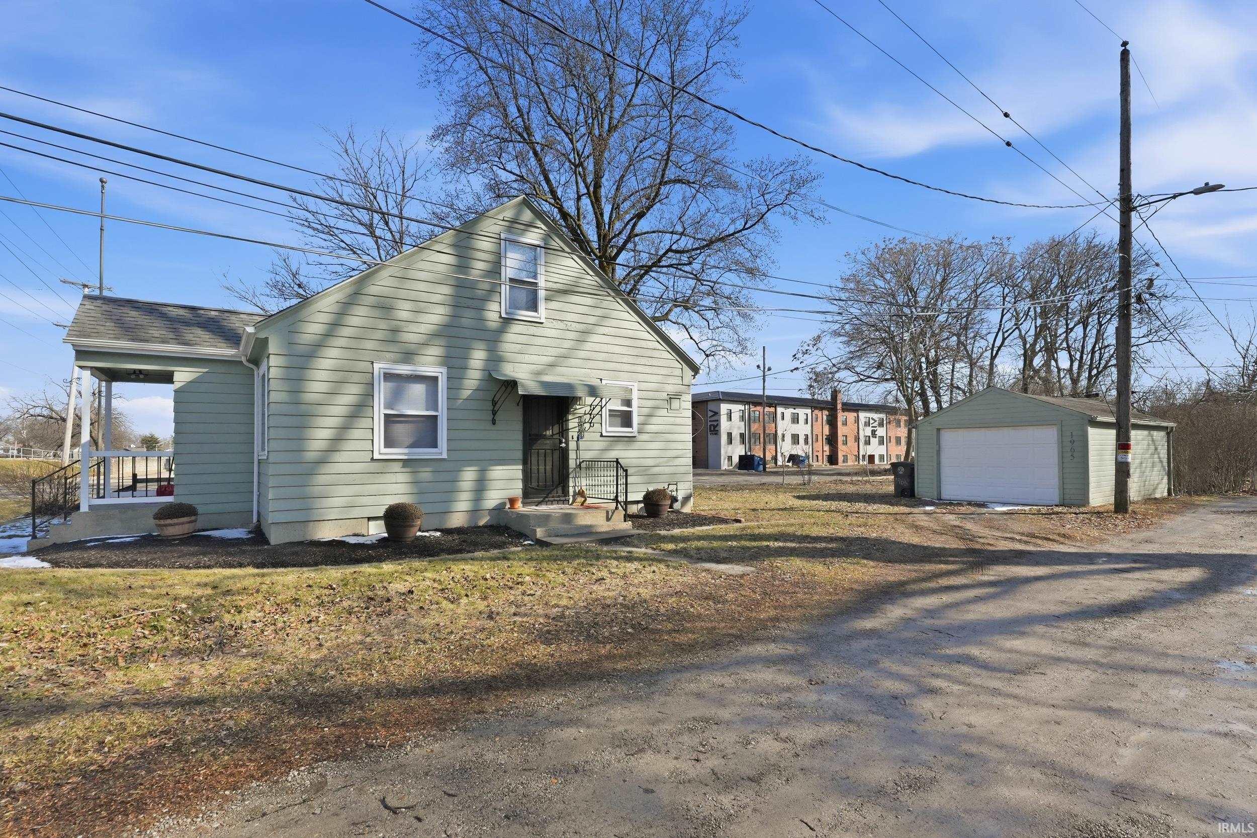 View of front of property with a garage, an outdoor structure, and driveway