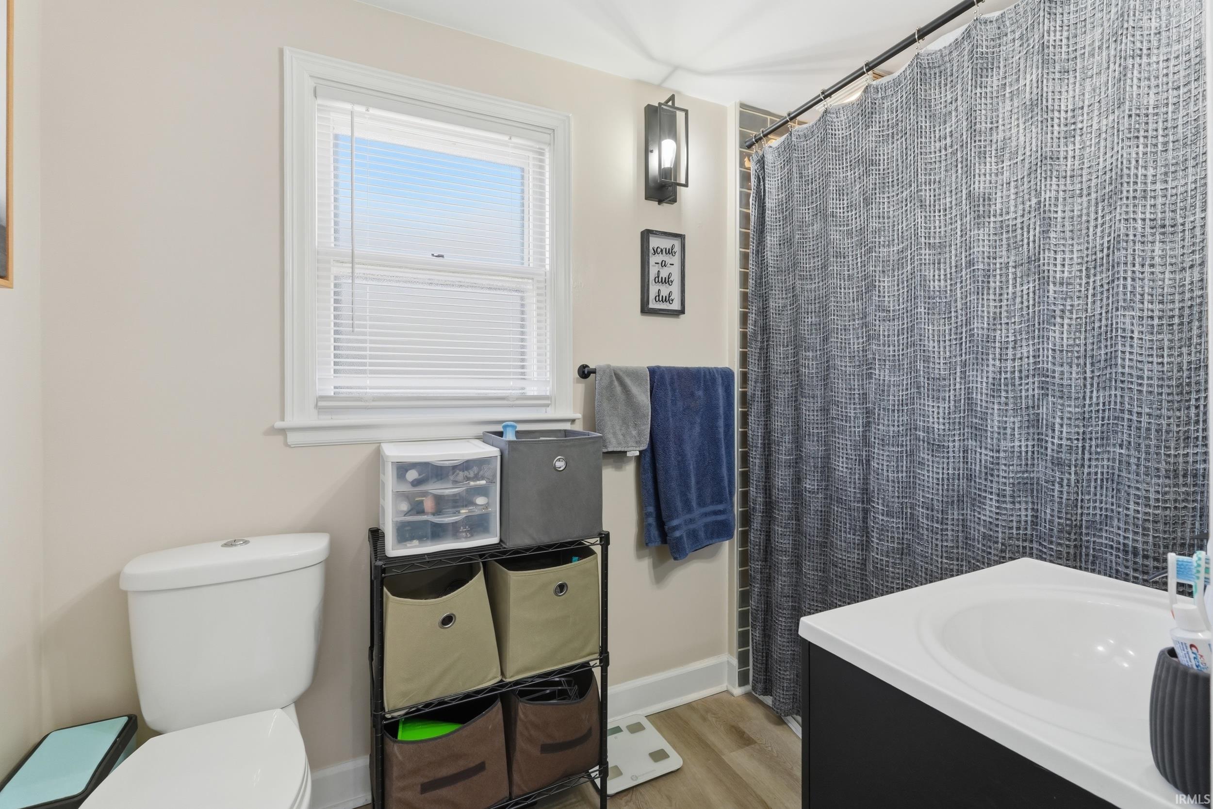 Full bathroom with a shower with curtain, vanity, and light wood finished floors