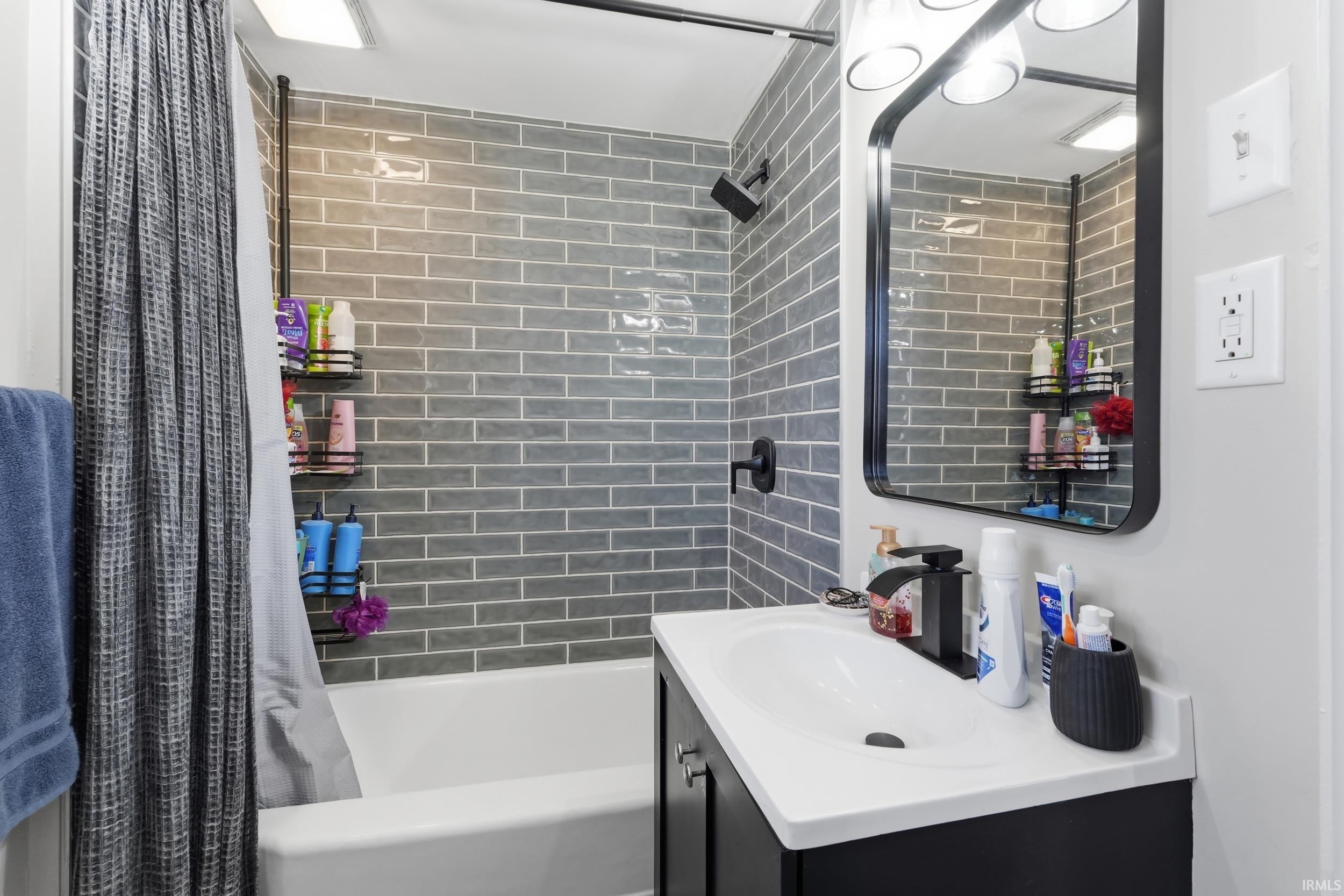 Full bath featuring vanity and shower / tub combo with curtain