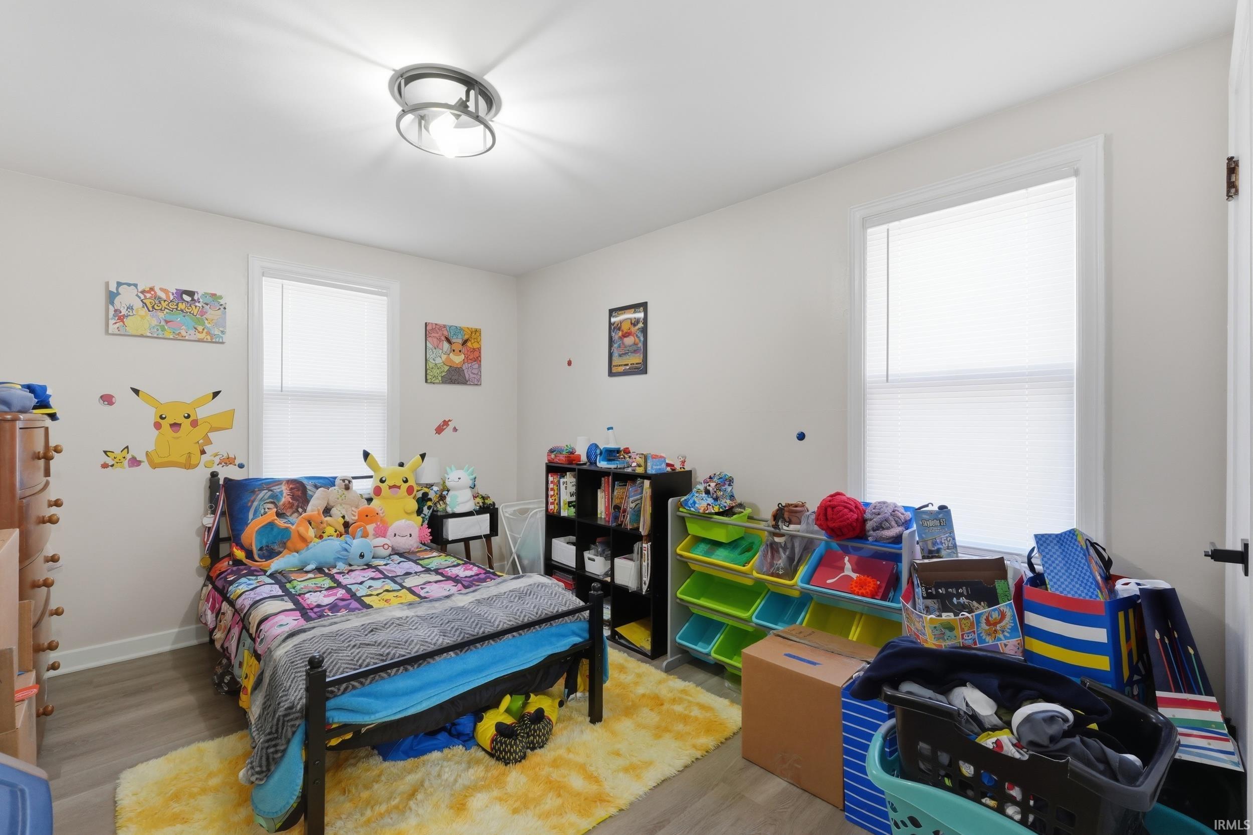 Bedroom with wood finished floors and baseboards