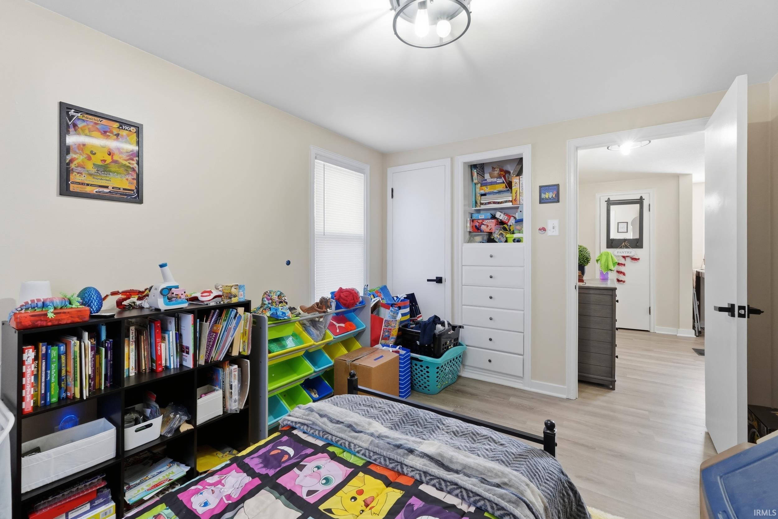 Bedroom featuring light wood finished floors and baseboards
