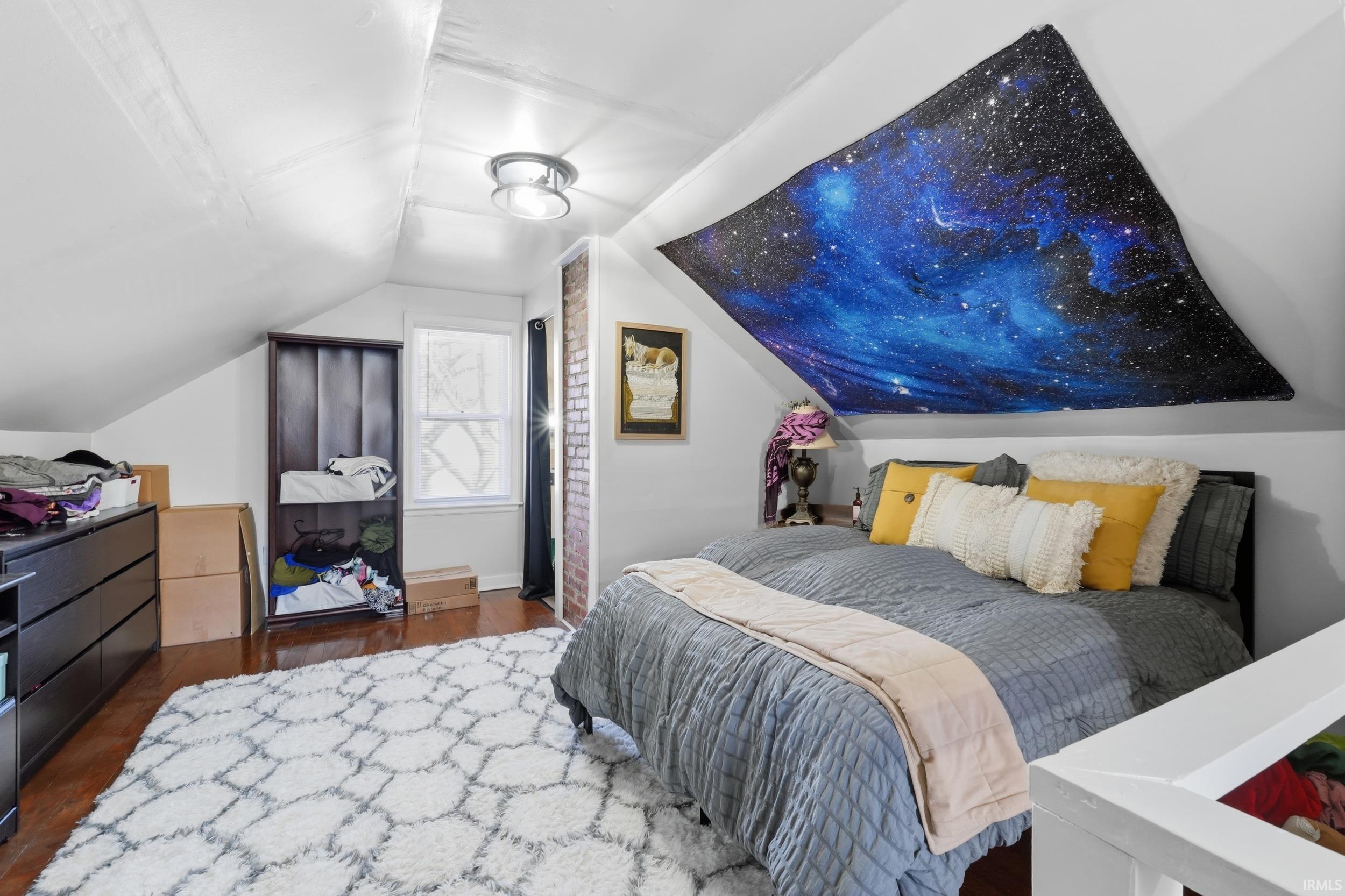 Bedroom featuring dark wood-type flooring and baseboards