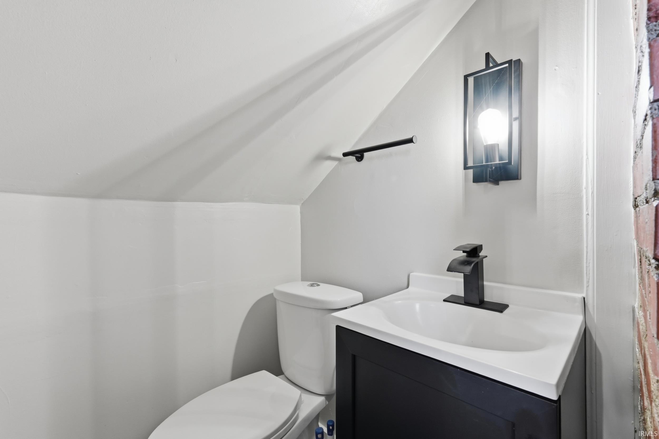 Bathroom featuring vanity and vaulted ceiling