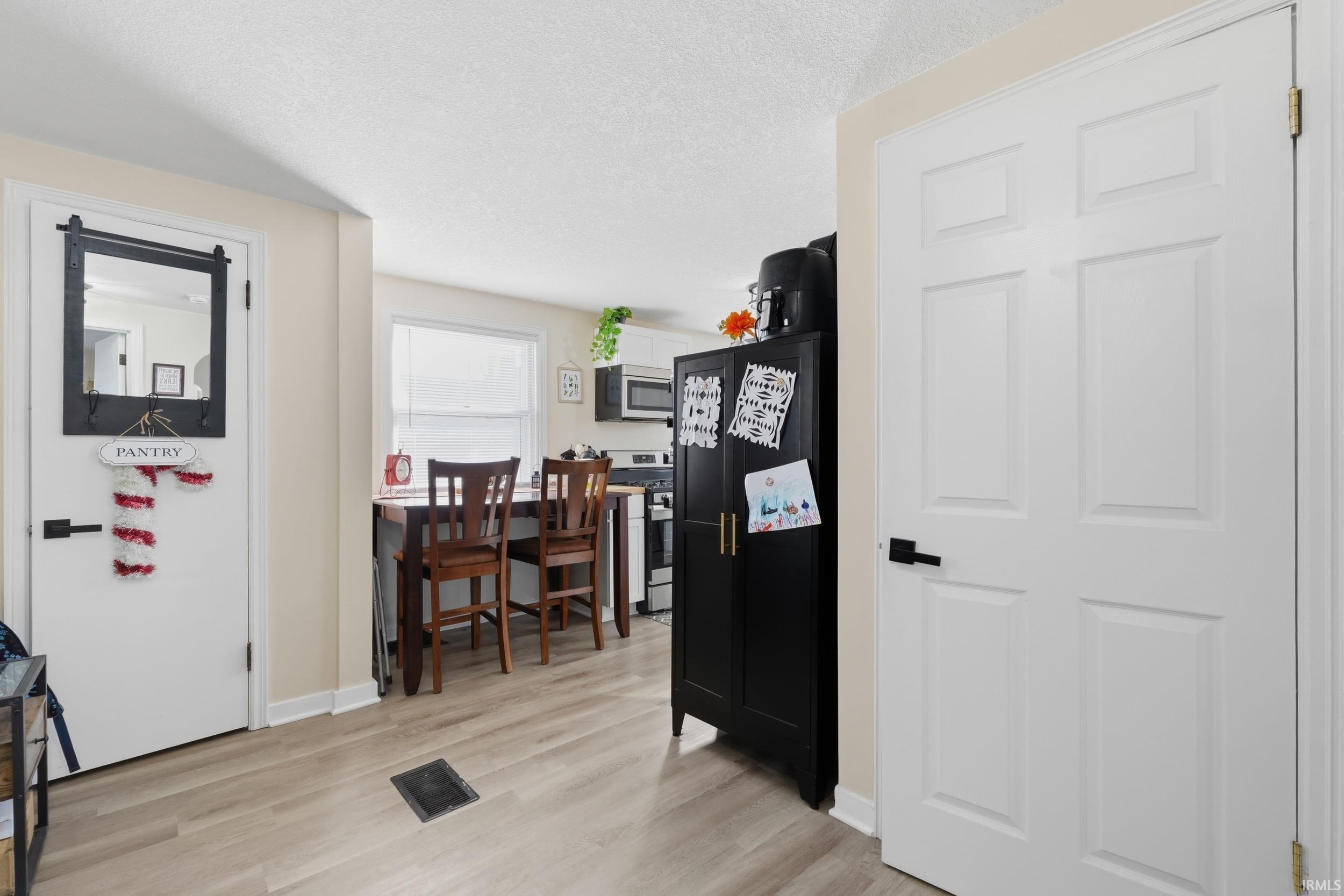Office space featuring light wood-style flooring and a textured ceiling