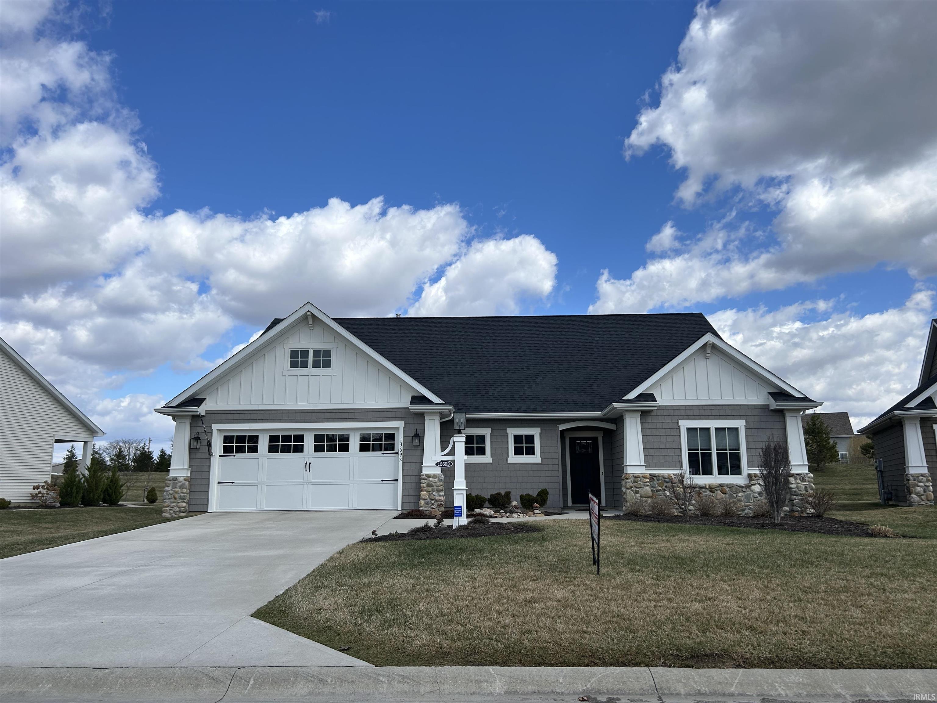 Craftsman house with board and batten siding, stone siding, and a front yard