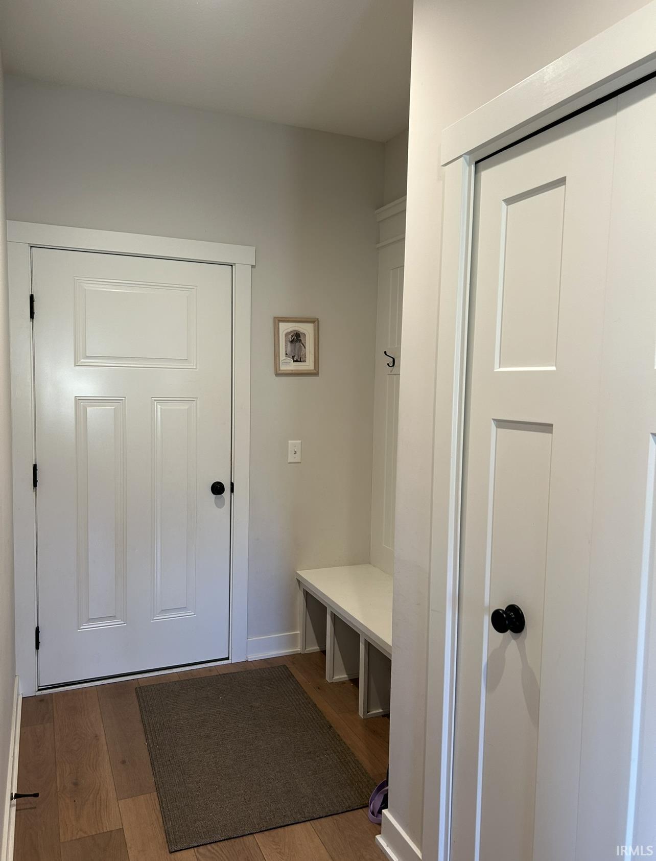 Mudroom featuring light wood finished floors and baseboards