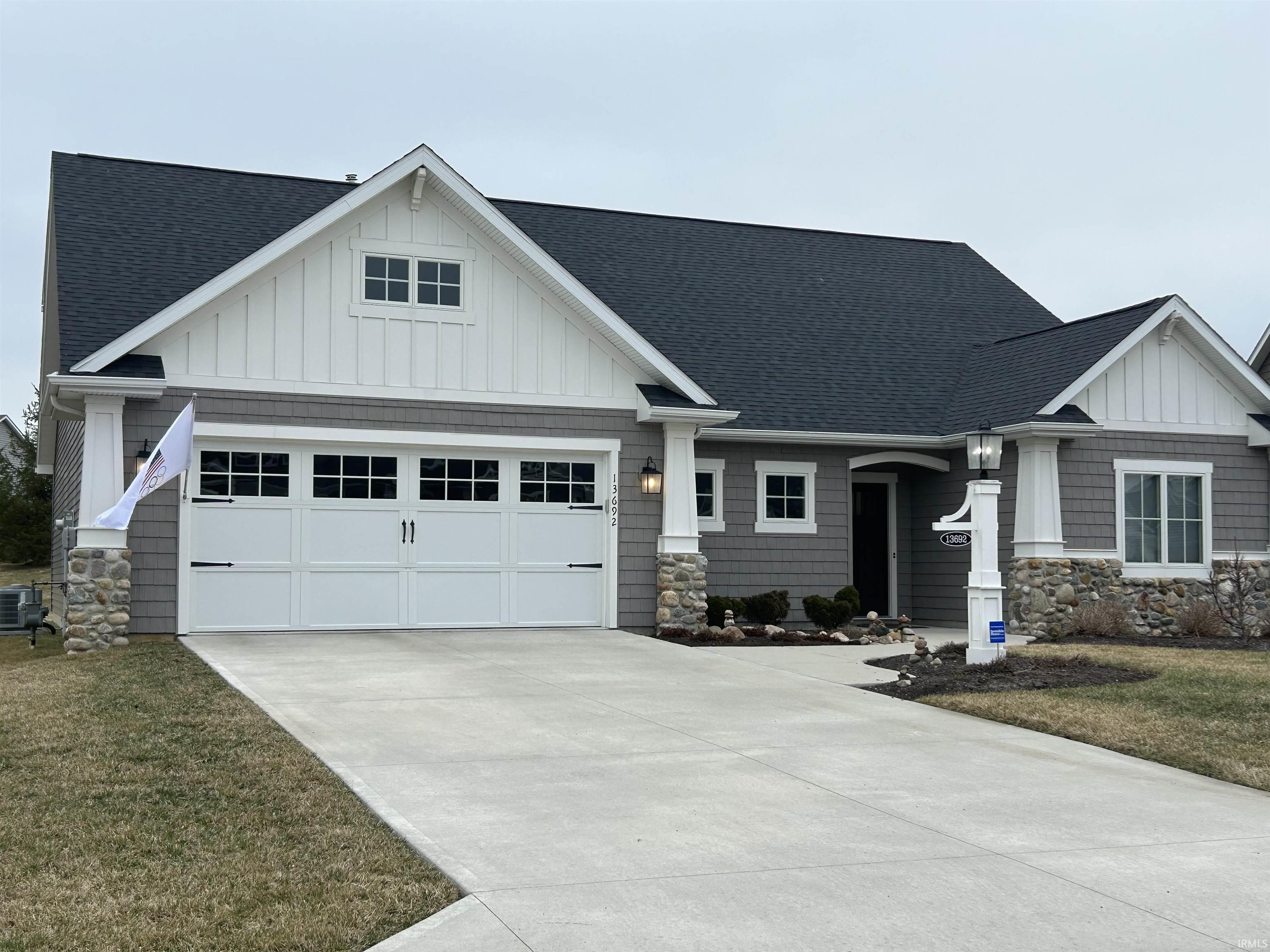 Craftsman-style house featuring a shingled roof, board and batten siding, and concrete driveway
