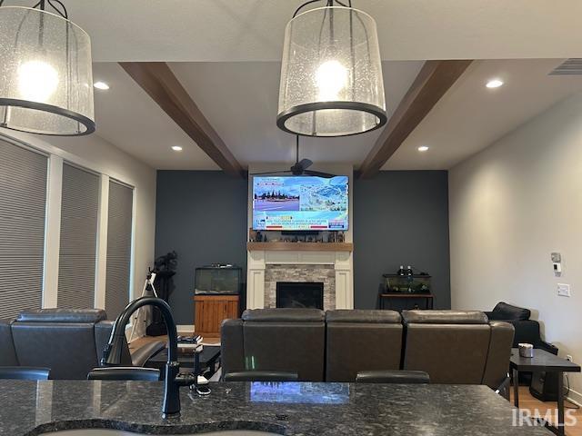 Living area with beamed ceiling, a fireplace, and recessed lighting