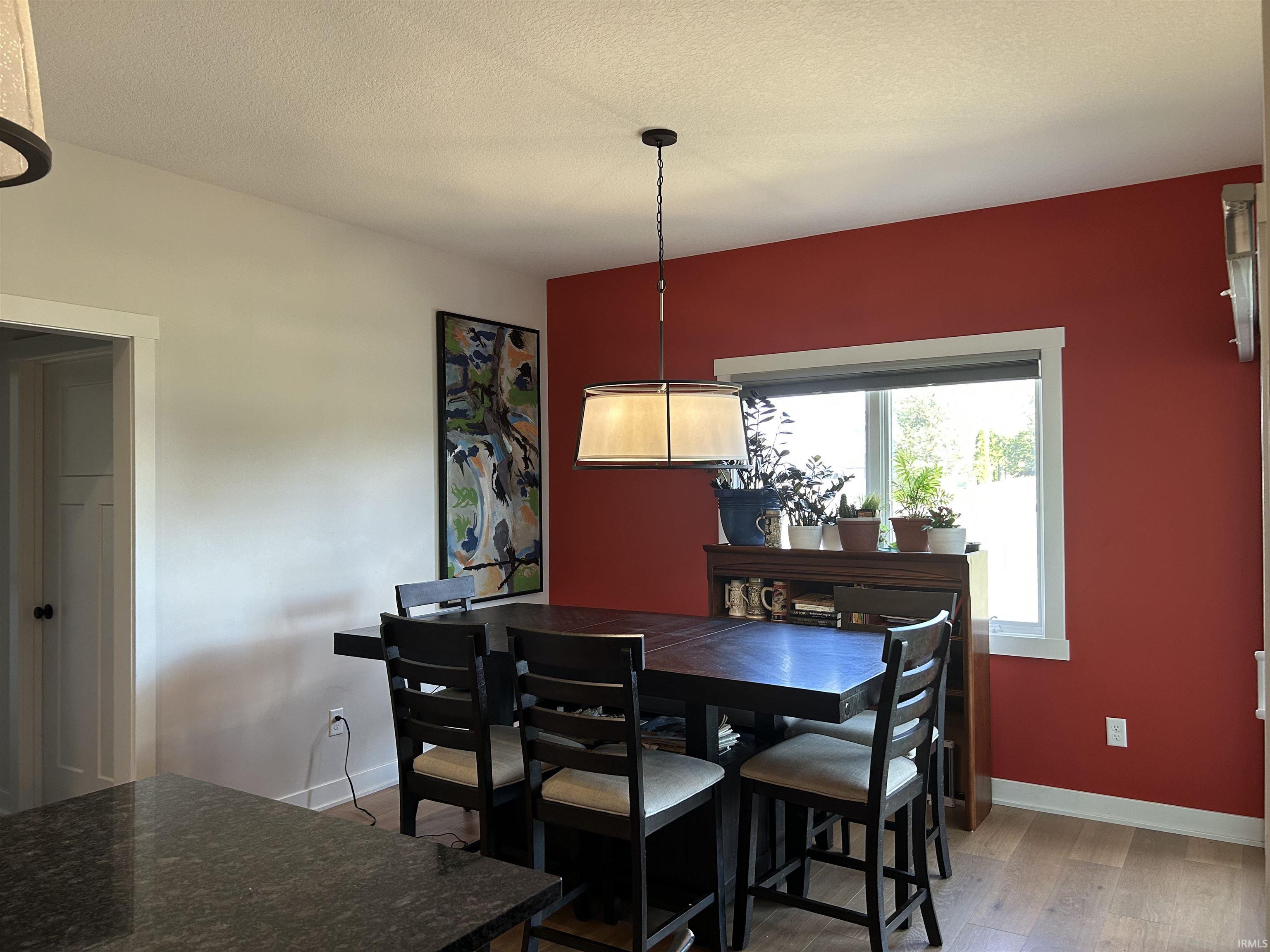 Dining room with a textured ceiling and light wood-style flooring