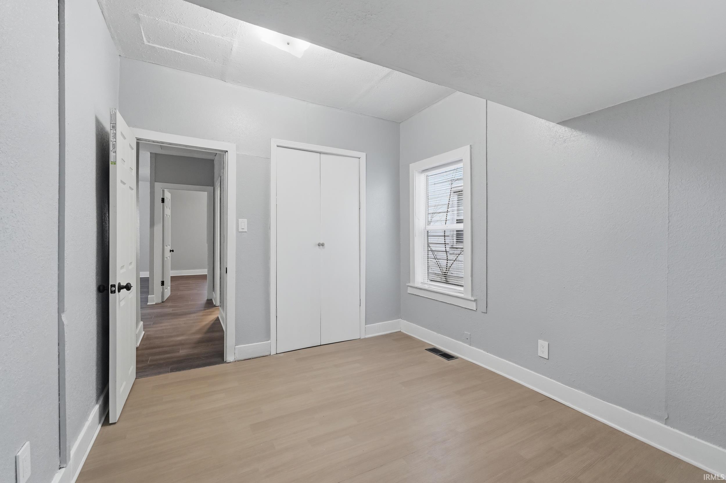 Unfurnished bedroom featuring light wood finished floors and a closet