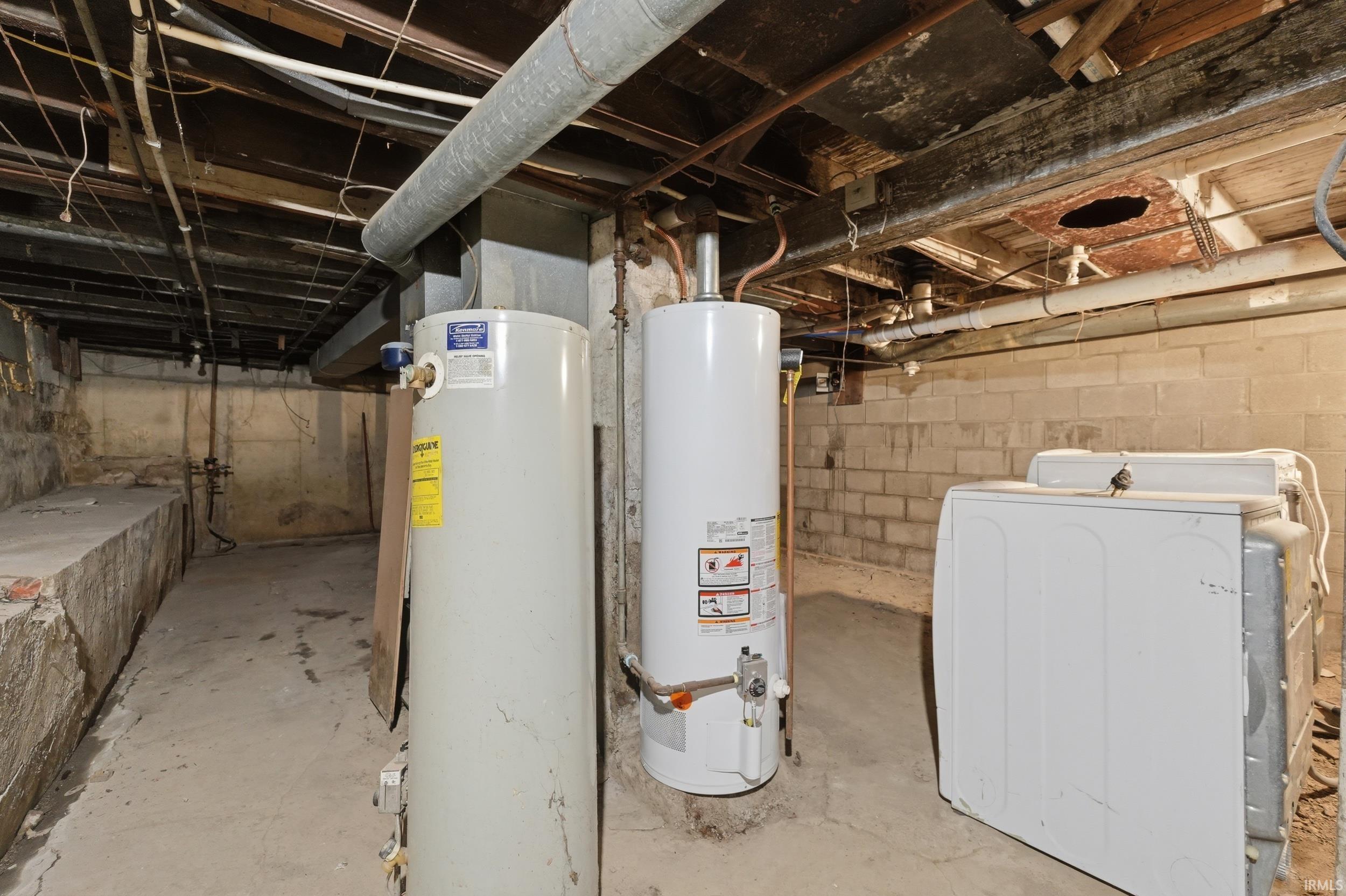 Unfinished below grade area featuring washer / clothes dryer and gas water heater